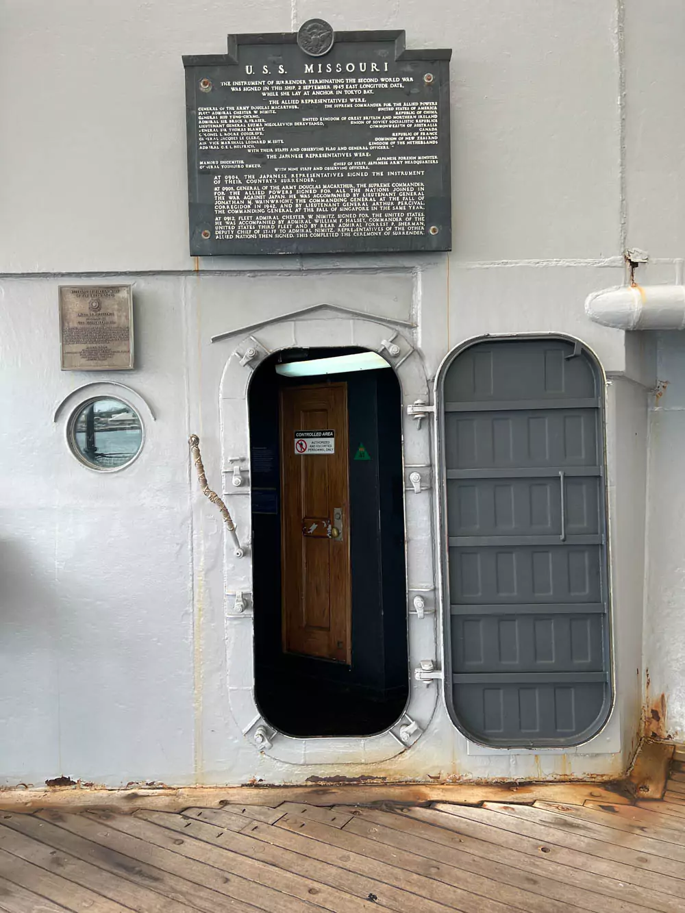 Entrance leading into the interior of the Battleship Missouri Memorial on Oʻahu, showing a narrow metal doorway with signage and bulkhead details typical of naval architecture.
