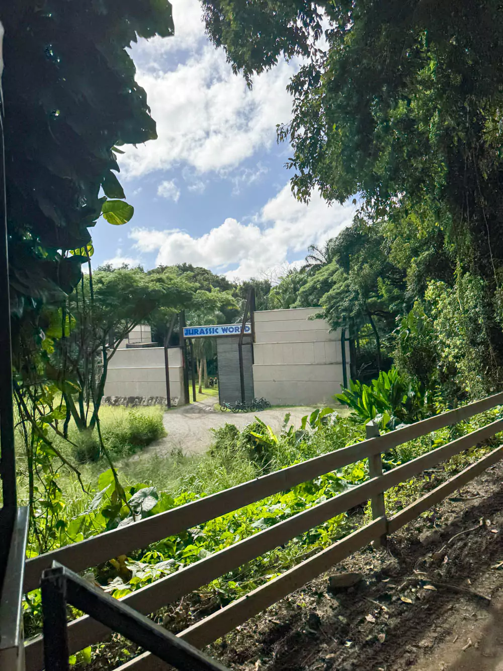 Film location of the Indominus Rex paddock from Jurassic World at Kualoa Ranch, featuring towering gates, reinforced concrete walls, and dense jungle surroundings in Jurassic Valley.