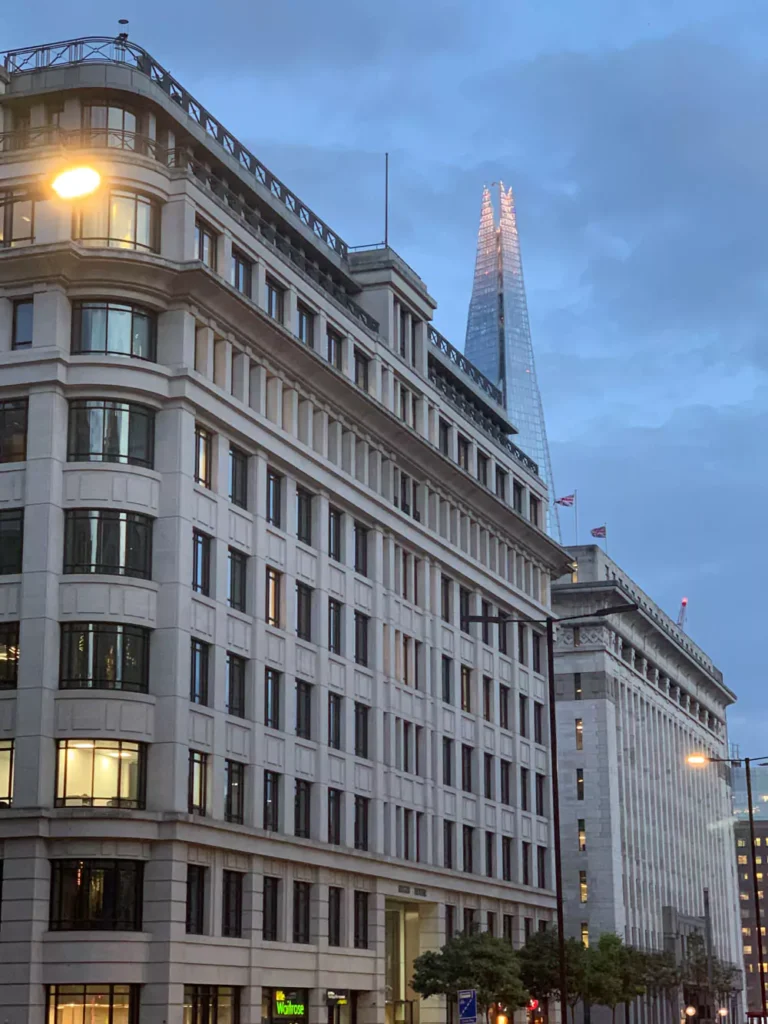 One Day London Itinerary - The Shard towering above the London skyline, its sleek glass structure tapering to a point and reflecting the sky. Surrounded by a mix of modern and historic buildings, the Shard stands as the tallest building in the UK and a striking city landmark.