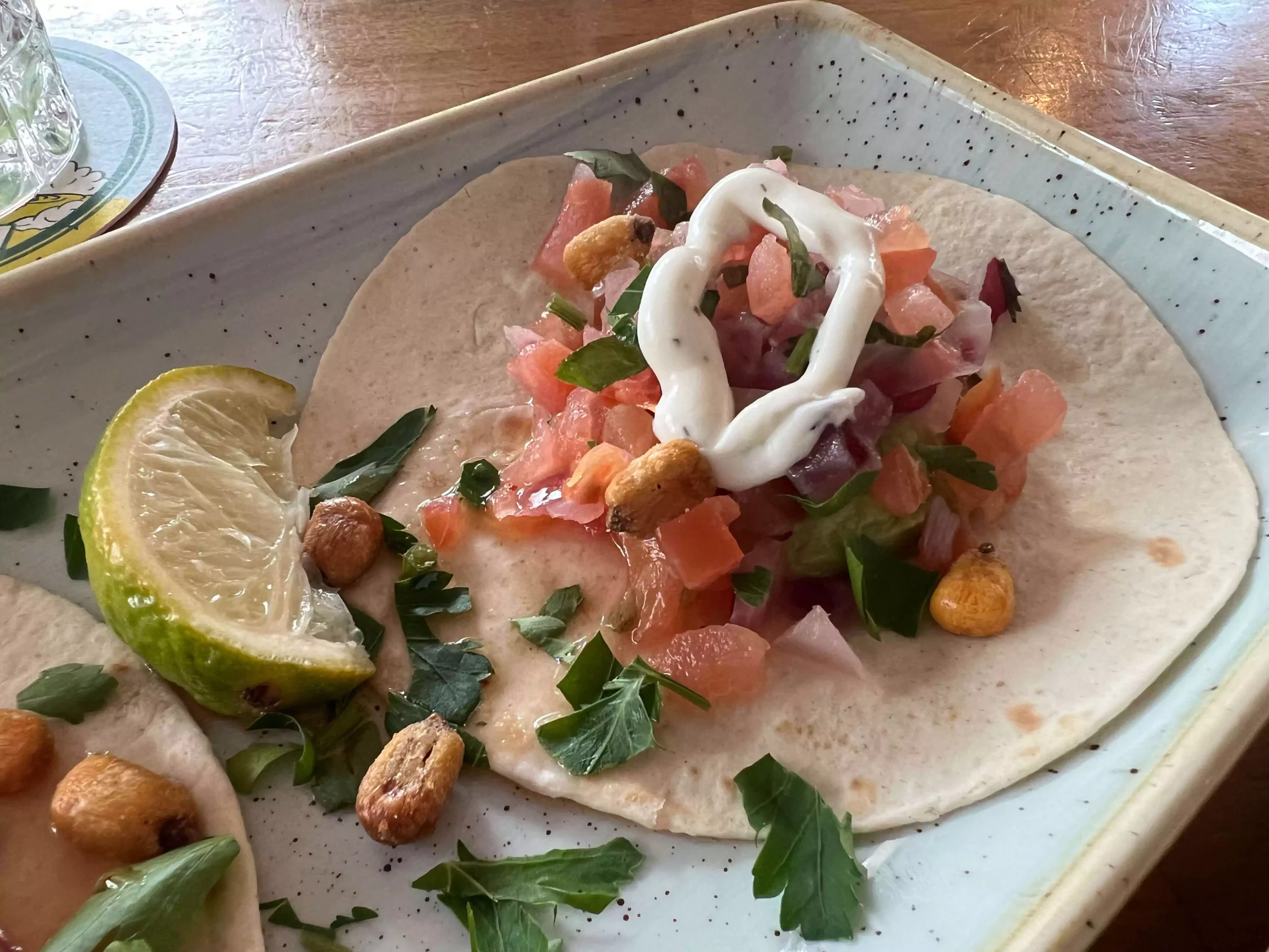 Taco served at Sausalitos in Nuremberg, Germany, filled with seasoned meat, fresh lettuce, diced tomatoes, cheese, and a drizzle of sauce, presented on a casual lunch plate.