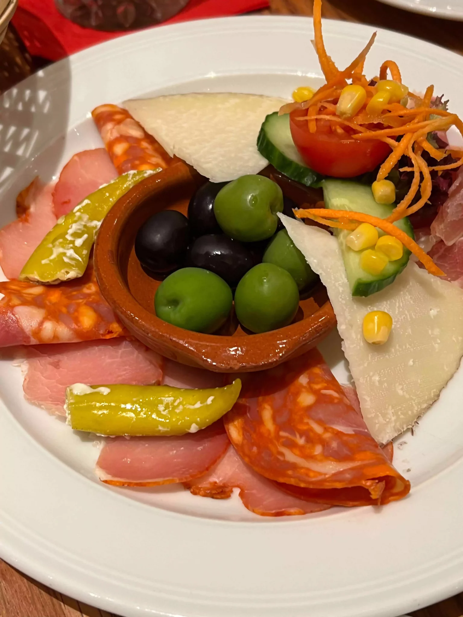 Appetizer plate for two with Serrano ham, embuchado sausage, chorizo, Manchego cheese, mixed olives, and stuffed peppers