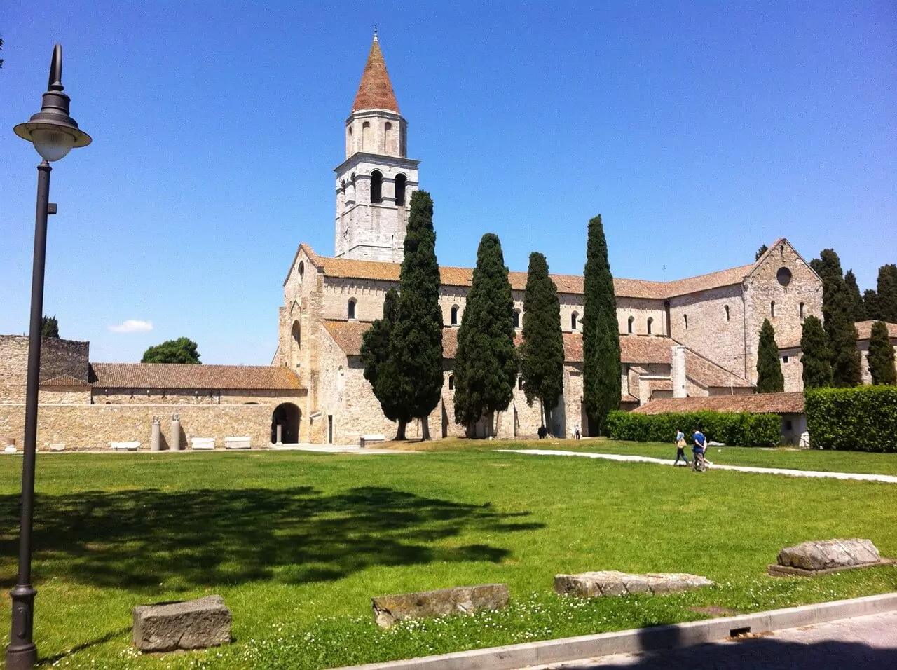 Roman ruins and the Basilica of Aquileia, Italy, with ancient columns and mosaics visible under open skies