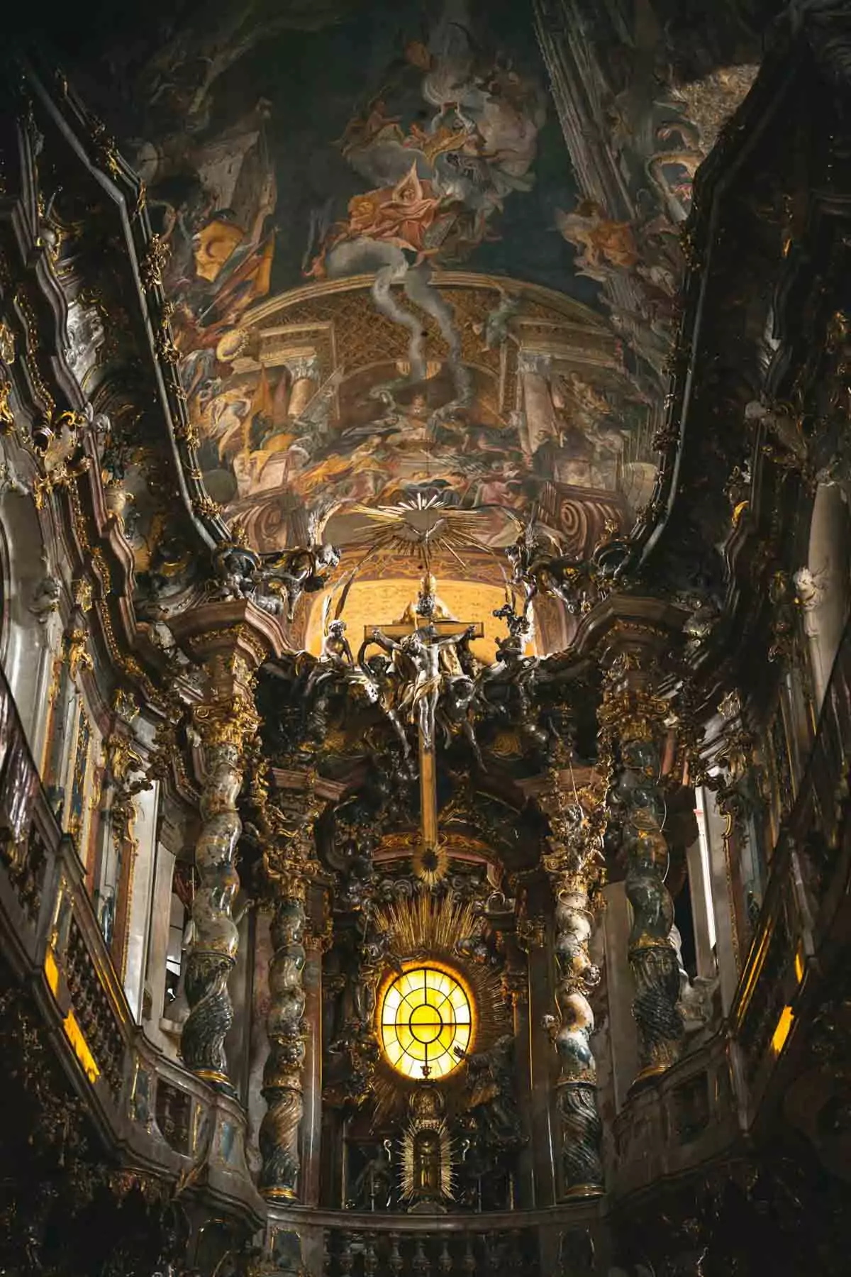 Ornate facade of Asamkirche (Asam Church) on Sendlinger Straße in Munich, Germany, featuring rich Baroque architecture with intricate sculptures, decorative columns, and a dramatic arched entrance.