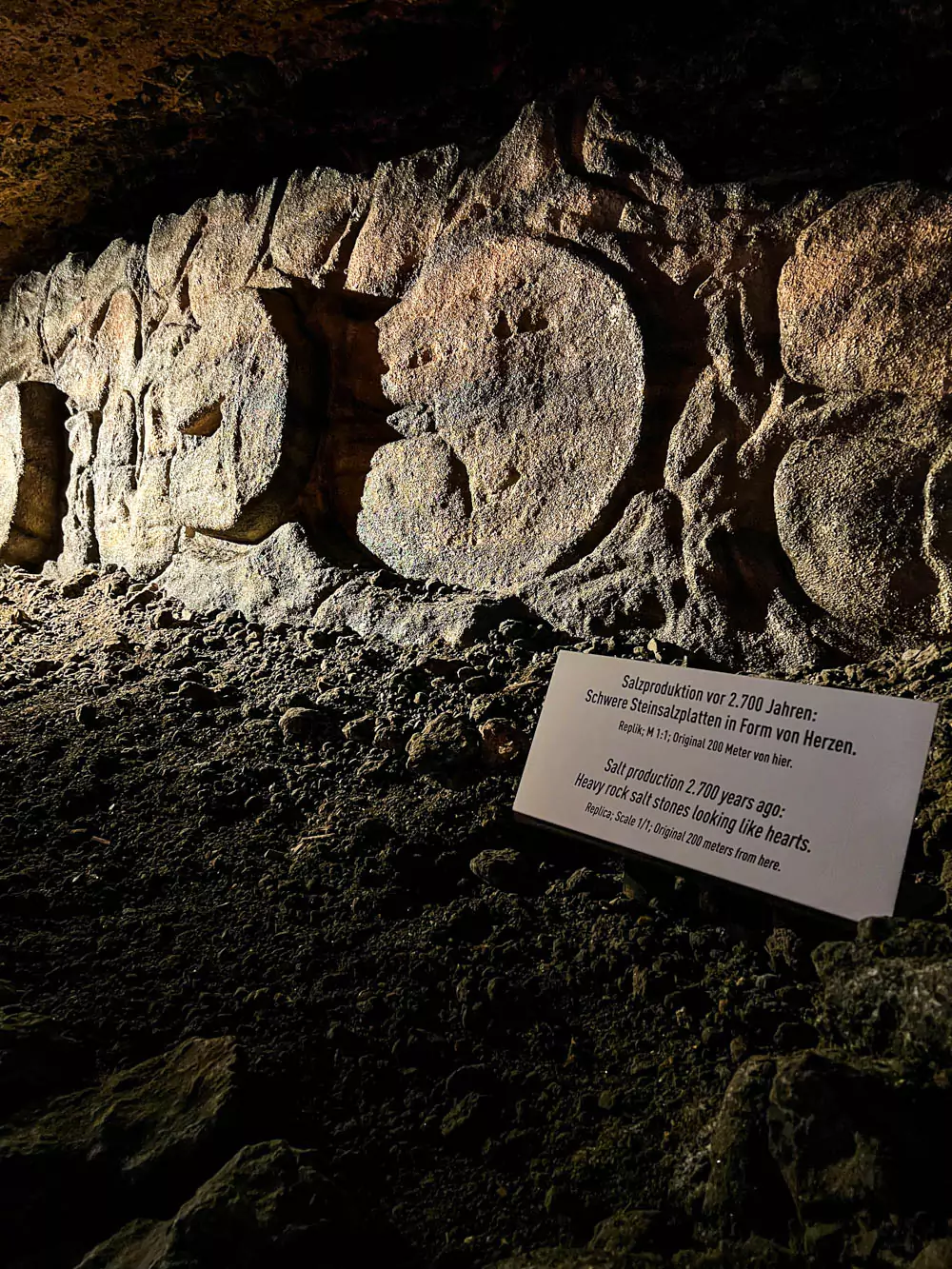 Heart-shaped salt stones on display at Hallstatt Salt Mine (Salzwelten), arranged neatly on a wooden surface. The pinkish-white crystals add a charming touch to the exhibit, blending natural beauty with symbolic form.