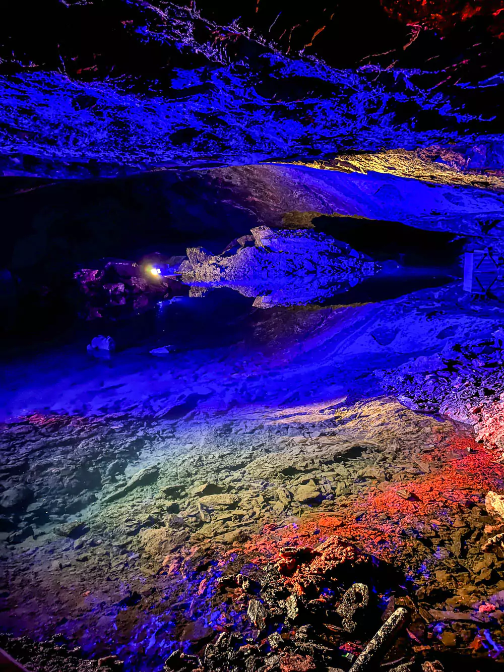 Underground lake at Hallstatt Salt Mine (Salzwelten), featuring still, mirror-like water reflecting dim lighting and salt-stained rock walls. The serene, otherworldly chamber showcases the natural beauty hidden deep within the historic mine.