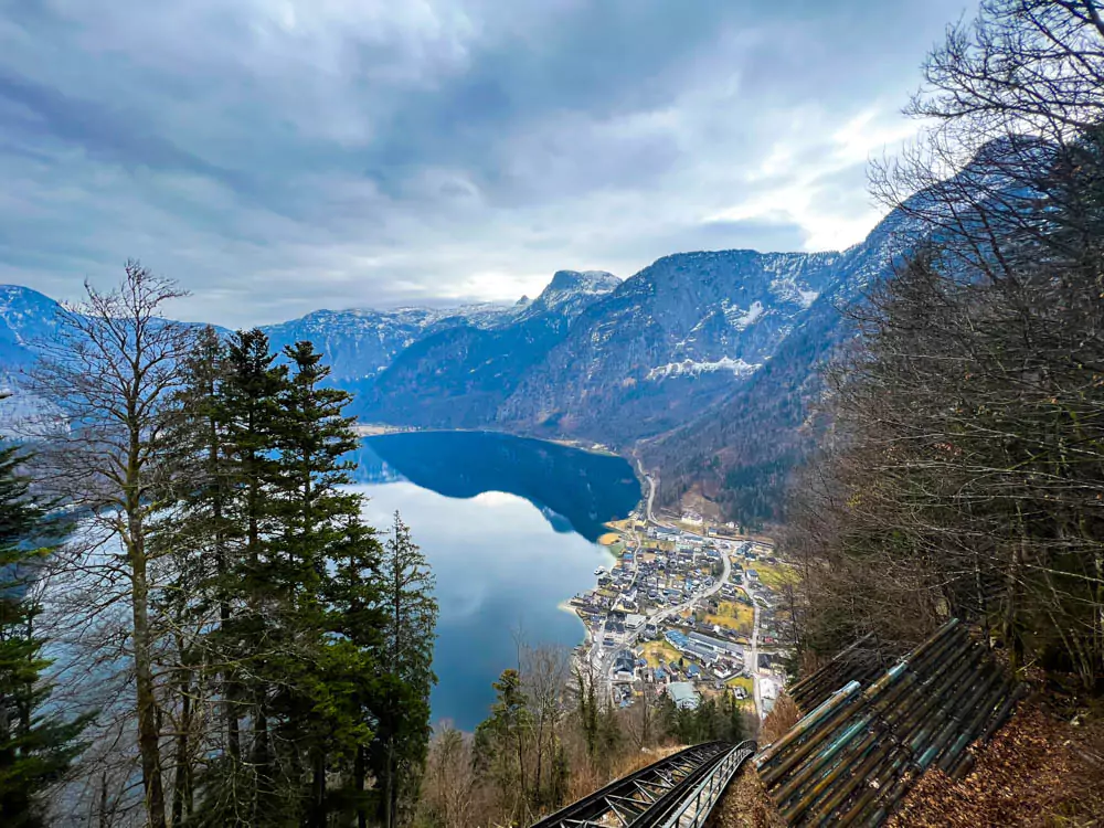 Scenic view from the funicular at Hallstatt Salt Mine (Salzwelten), looking down over the alpine forest and rooftops of Hallstatt below. The steep descent offers panoramic sights of the lake, village, and surrounding mountains.
