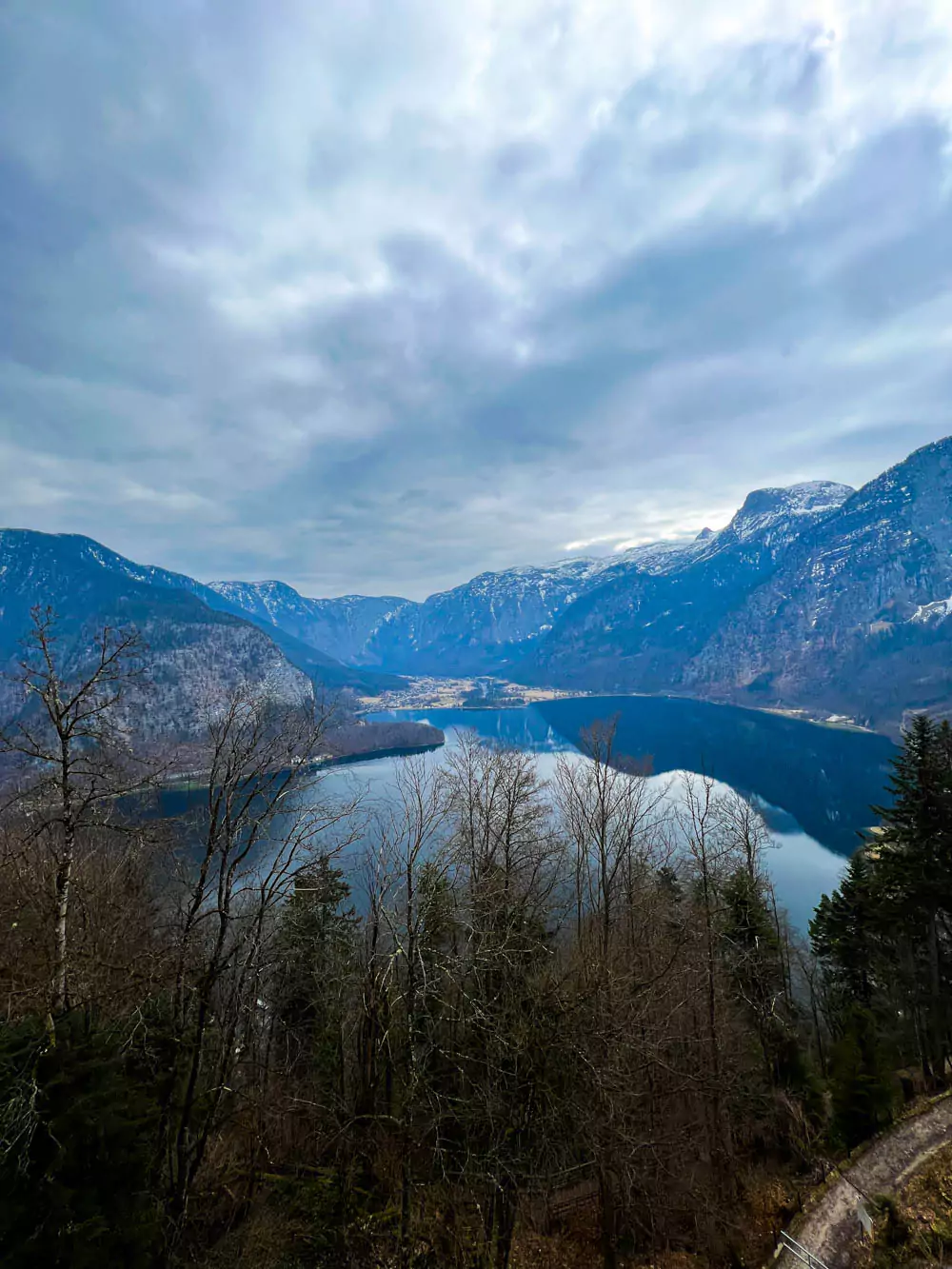 Stunning view of Hallstätter See from the Hallstatt Salt Mine (Salzwelten), with the lake’s calm blue waters framed by forested mountains and scattered alpine houses. The high vantage point offers a peaceful and picturesque scene of the Austrian countryside.
