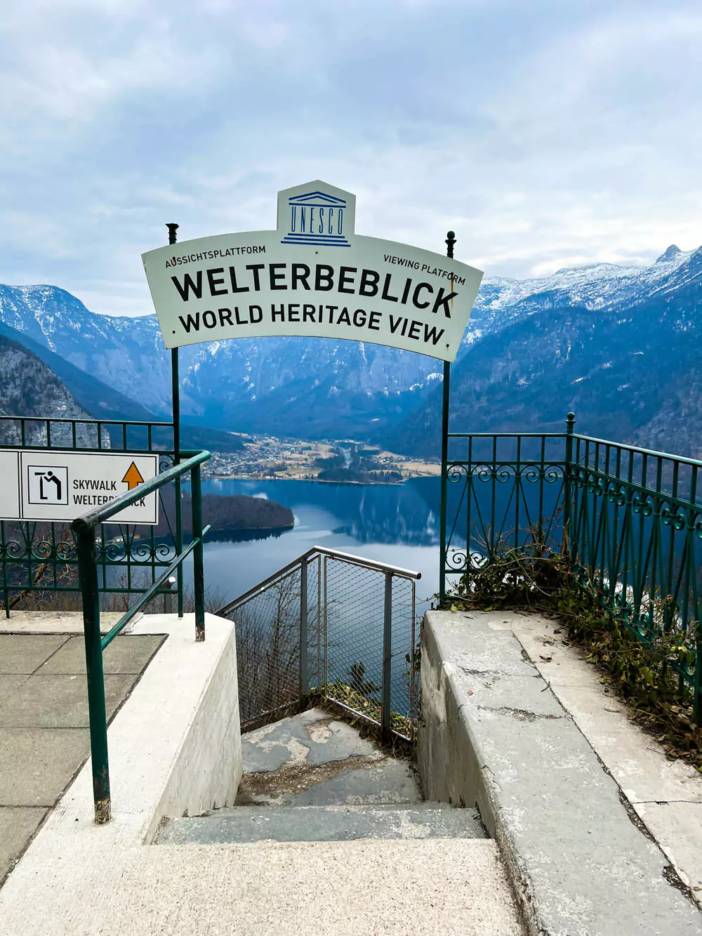 Welterbeblick Skywalk sign at Hallstatt Salt Mine (Salzwelten), marking the entrance to the panoramic viewing platform. The sign stands against a backdrop of alpine scenery, guiding visitors to the breathtaking overlook of Hallstatt and Hallstätter See.