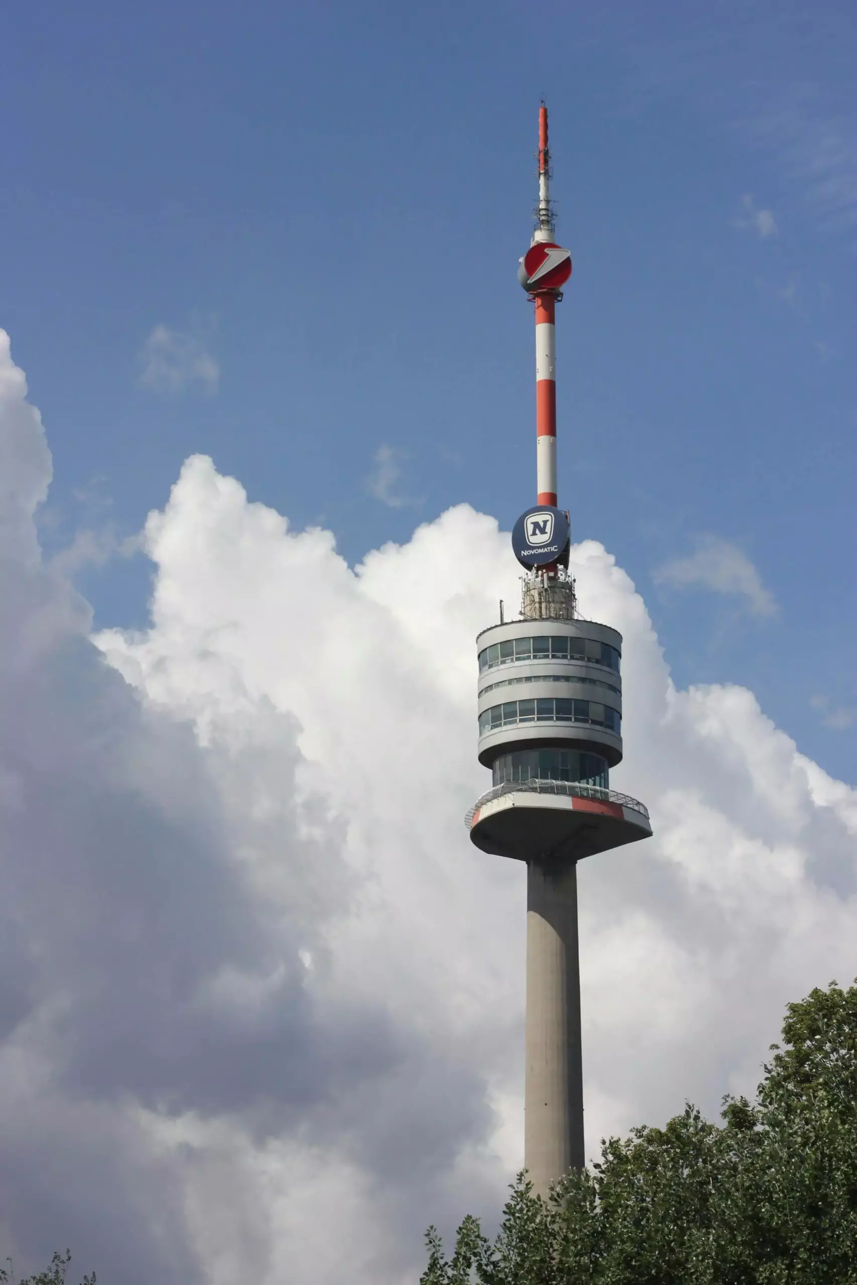 Danube Tower (Donauturm) in Vienna, Austria, a tall concrete observation tower with a circular viewing platform and revolving restaurant at the top, overlooking the Danube River and surrounding cityscape.