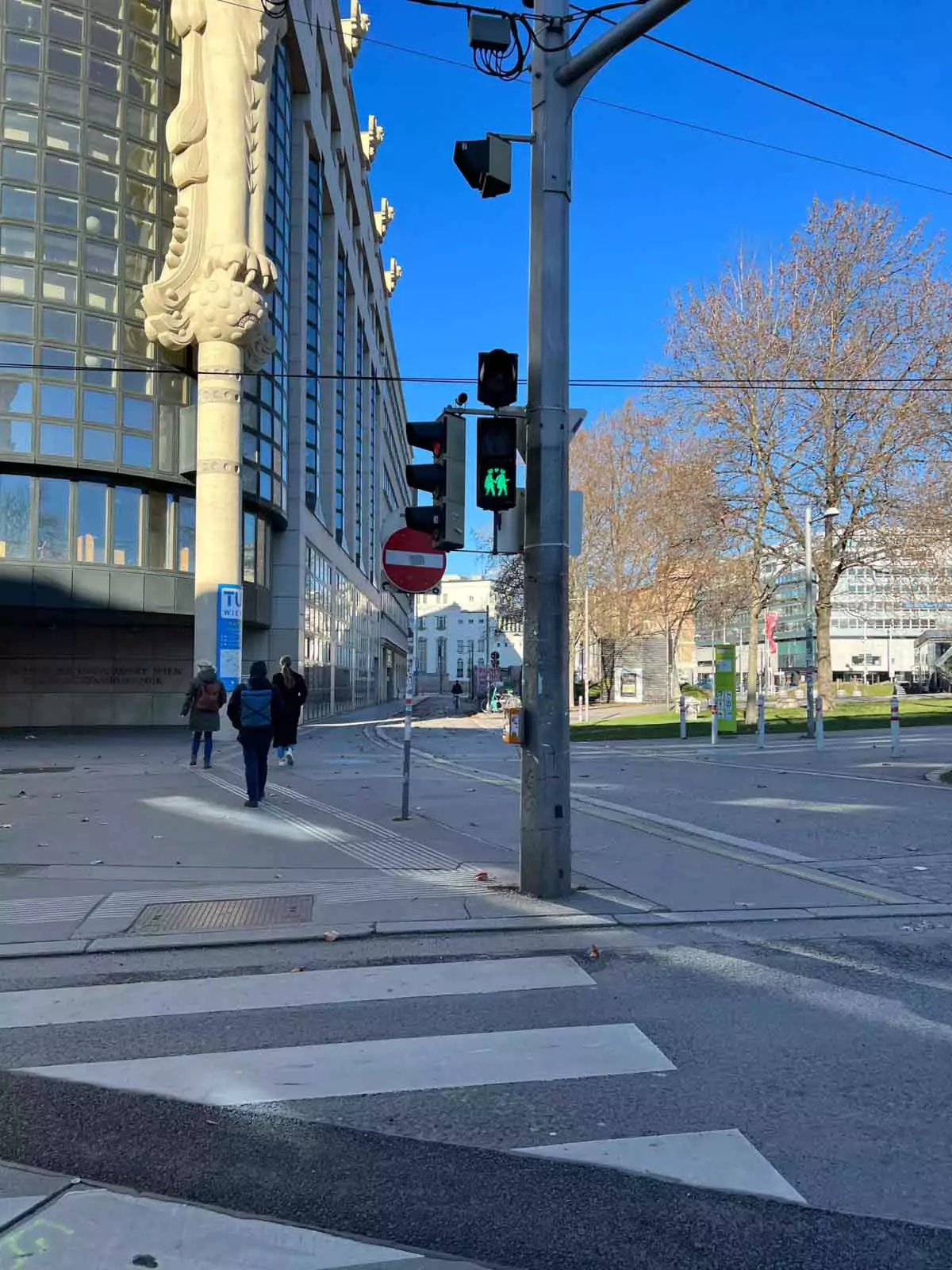 Green pedestrian crosswalk signal in Vienna, Austria, showing two people holding hands, part of the city’s inclusive traffic light designs promoting diversity and equality.