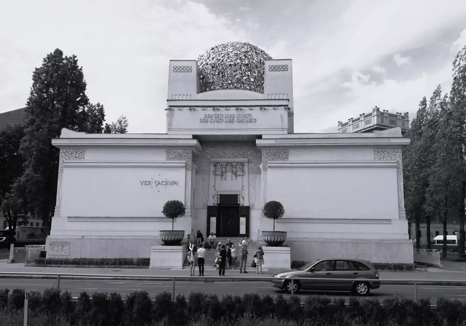 Vienna Secession Building in Austria, featuring a white façade with minimal ornamentation and a gilded dome of laurel leaves, symbolizing the city's turn-of-the-century art movement and the motto “To every age its art, to every art its freedom.”
