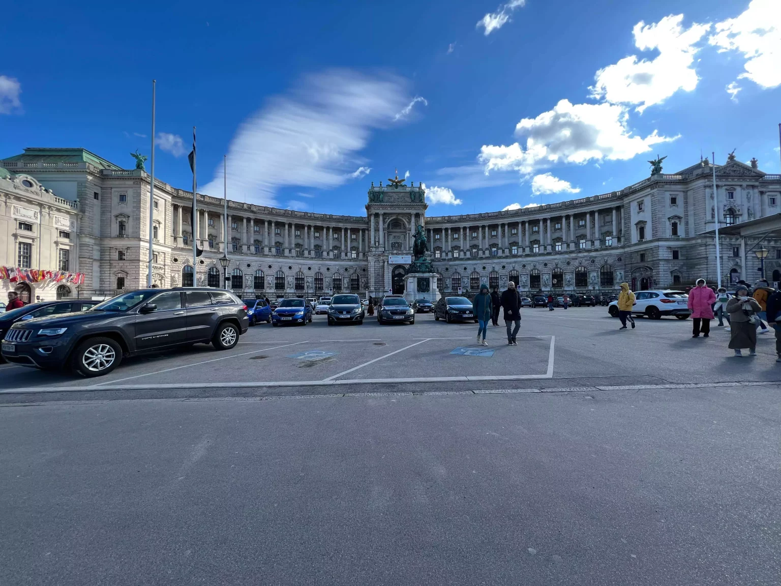 The grand exterior of Hofburg Palace in Vienna, Austria, featuring Baroque architecture, ornate statues, and a curved façade with green domes, once serving as the imperial residence of the Habsburg dynasty.