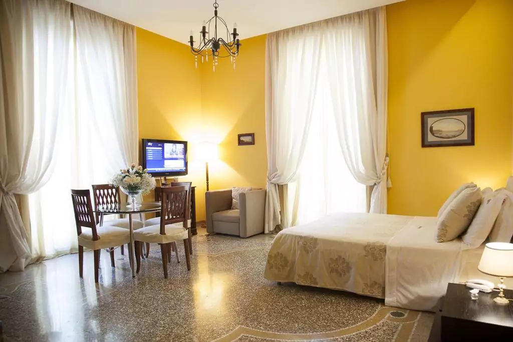 Bedroom at B&B Orsini in Naples, Italy, featuring a comfortable double bed with crisp white linens, classic wooden furnishings, and soft lighting — a cozy and inviting stay