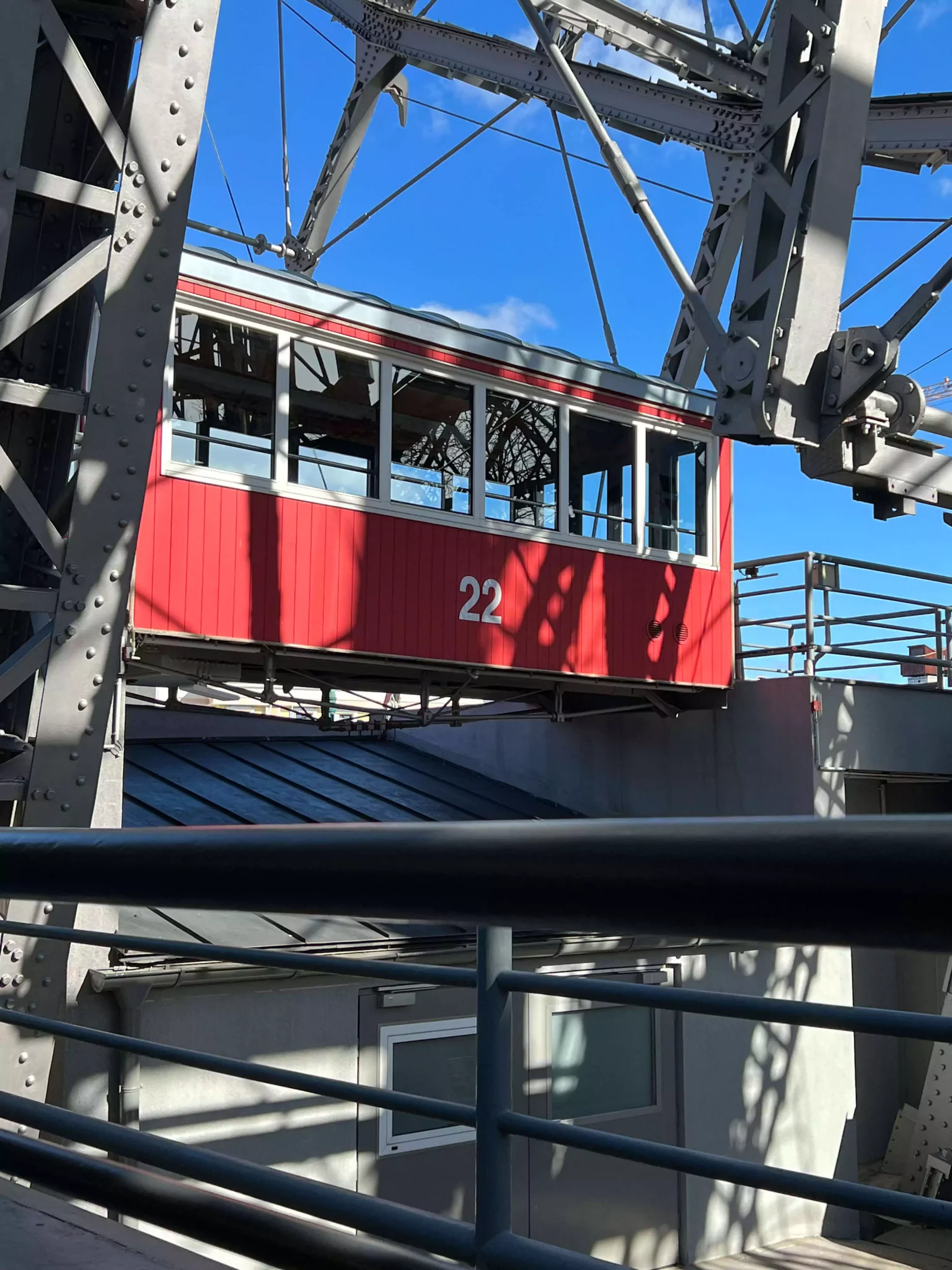 Car 22 on the giant Ferris wheel in Vienna, Austria, is a classic red cabin with white numbering, suspended against the city skyline