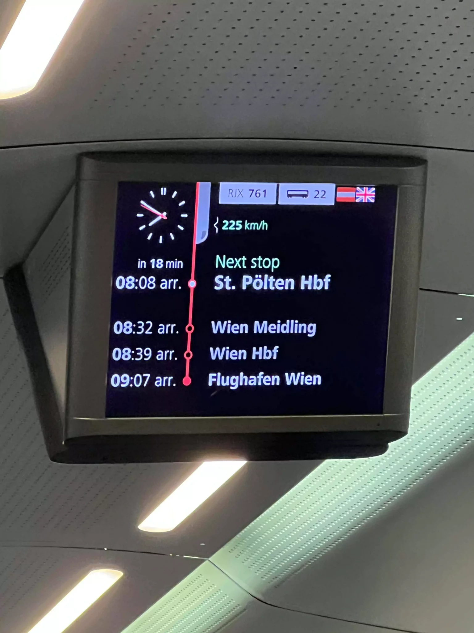 A digital sign inside a train to Vienna displays the arrival time as 8:39 AM. The sleek LED screen glows with bright text, keeping passengers informed as they approach their destination.