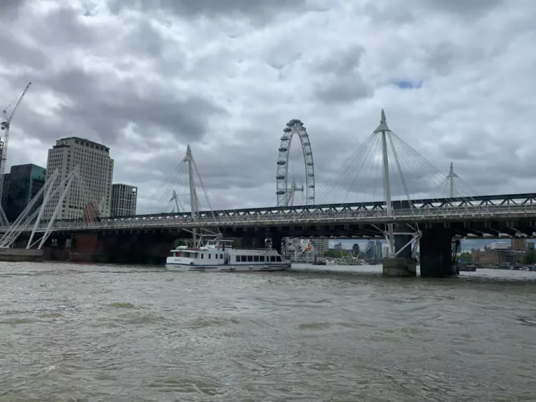 The London Eye towering over the River Thames, with its glass pods offering panoramic views of the city. The iconic observation wheel is a highlight of a 2-day London itinerary, set against a backdrop of historic landmarks and the flowing river.