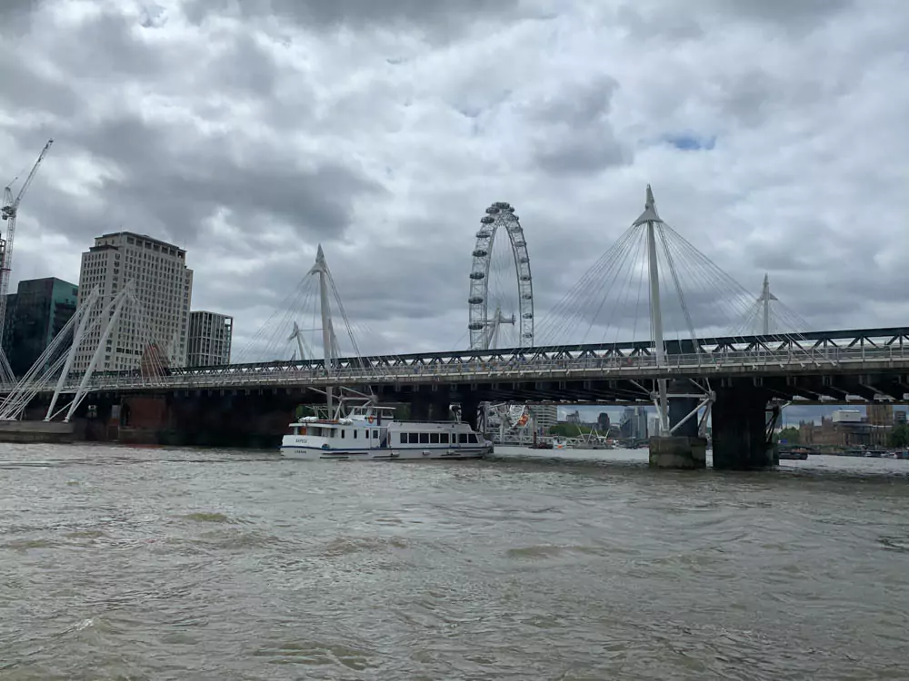The London Eye towering over the River Thames, with its glass pods offering panoramic views of the city. The iconic observation wheel is a highlight of a 2-day London itinerary, set against a backdrop of historic landmarks and the flowing river.