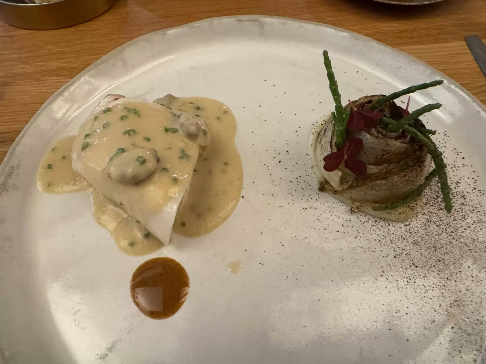 Main course fish dish served at Auberge Nicolas Flamel in Paris, France, featuring a perfectly cooked fillet with seasonal vegetables and a light sauce, elegantly plated in a fine dining setting.
