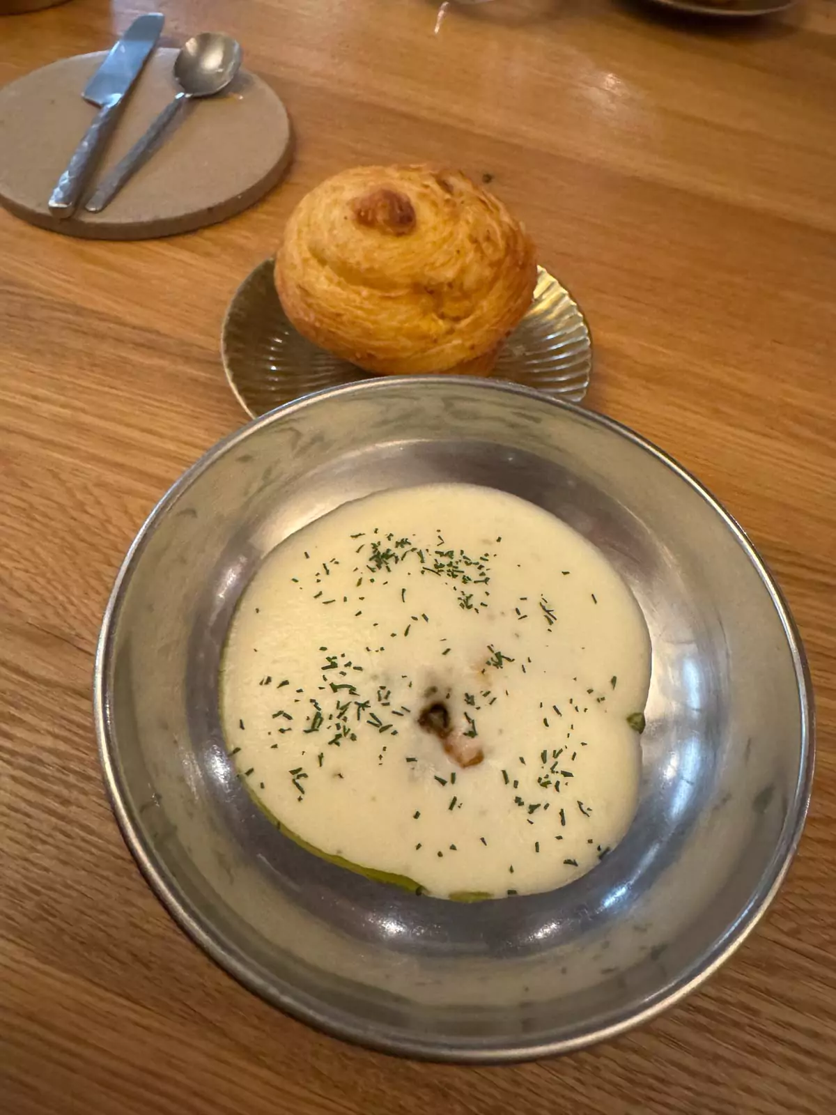 Buttery roll served with a creamy, cheese-like dipping sauce at Auberge Nicolas Flamel in Paris, France, presented as part of a refined lunch course in a historic fine dining setting.