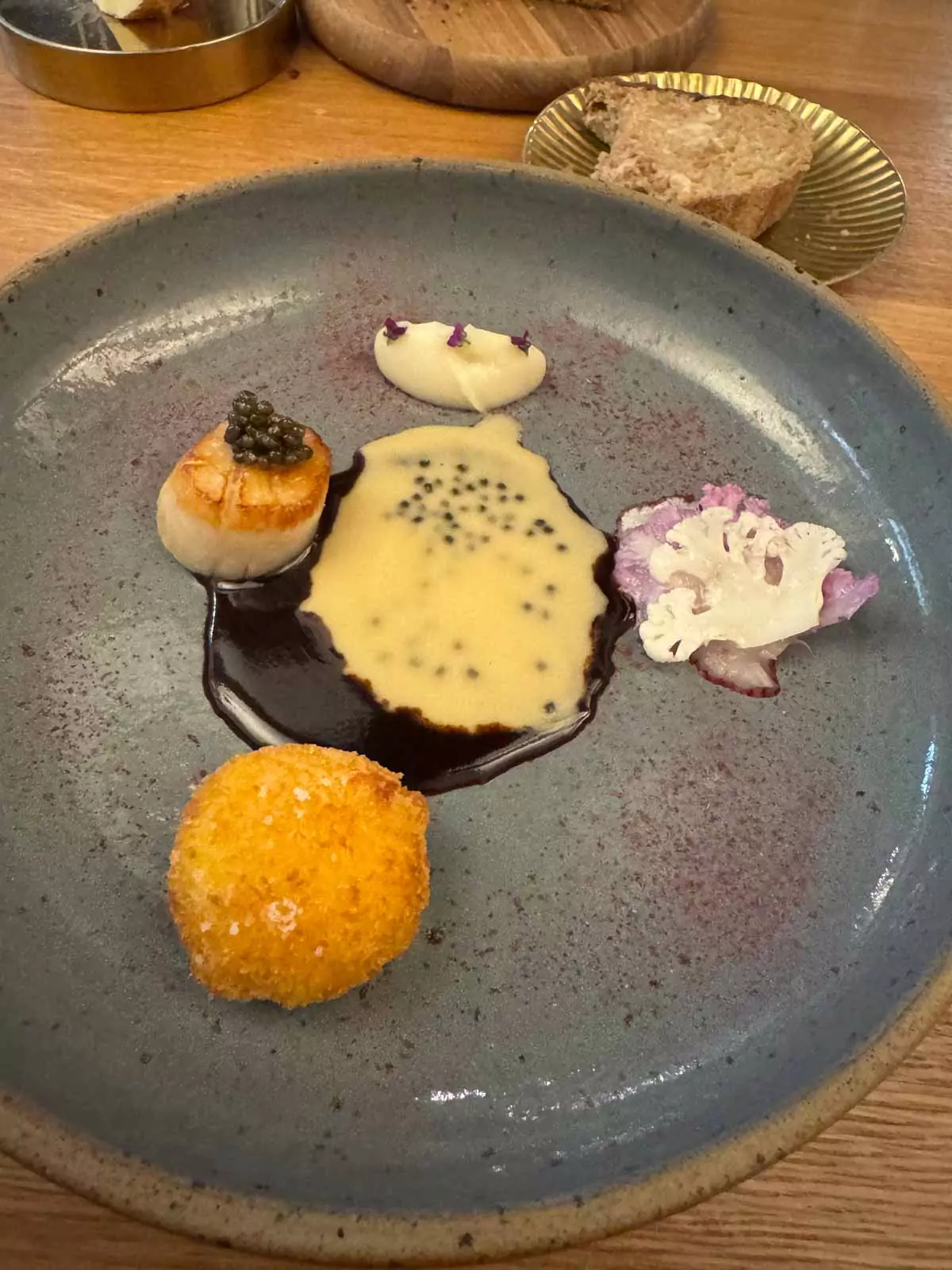 Saint-Jacques scallops with cauliflower and Kristal caviar served at Auberge Nicolas Flamel in Paris, France, presented with artistic plating and gourmet detail in a fine dining setting.