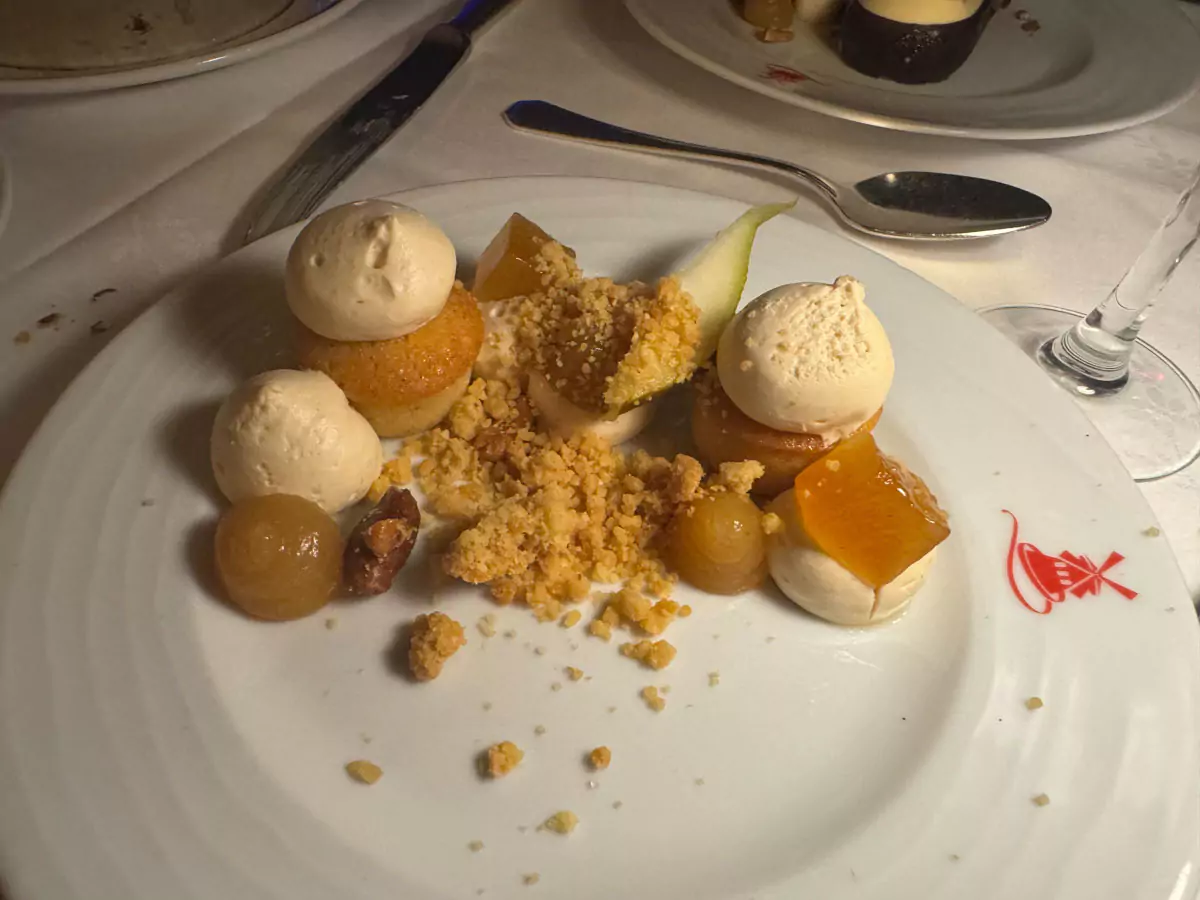Dessert served at a Montmartre café near the Moulin Rouge in Paris, France, featuring a whipped ganache topped with roasted peanuts, elegantly plated and set against a cozy Parisian backdrop.