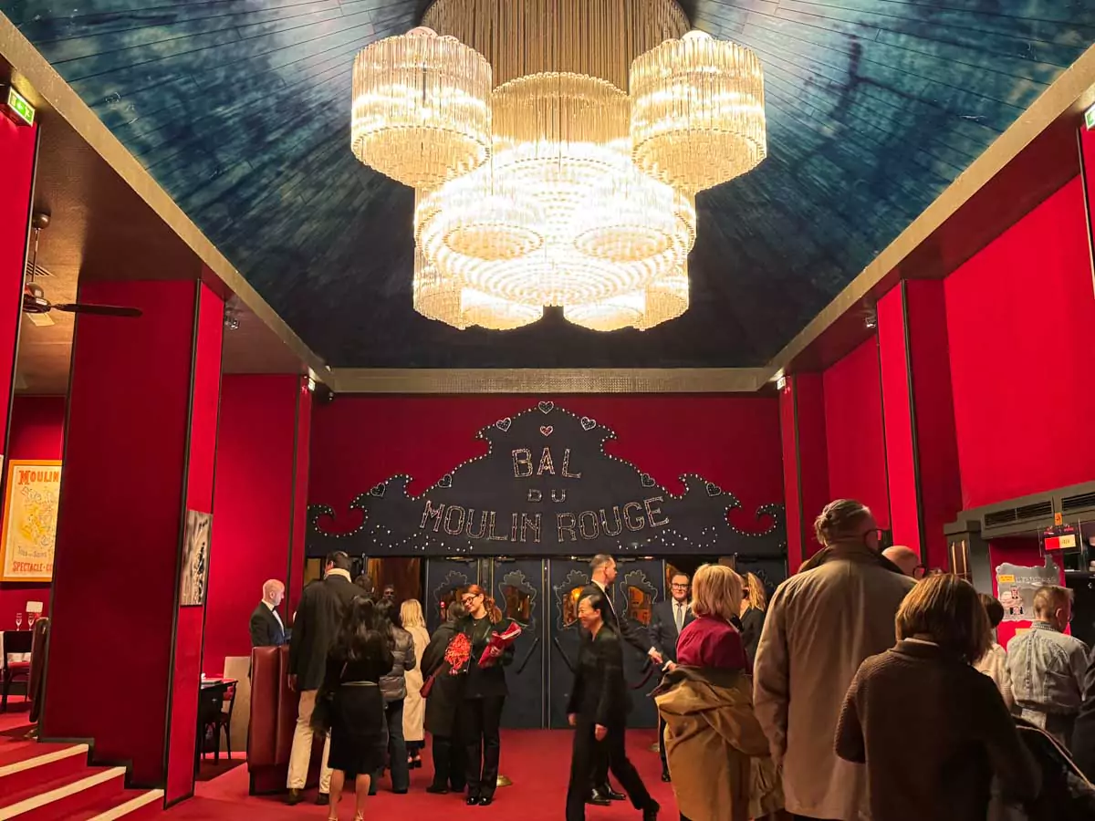 Inside the foyer of the Moulin Rouge in Montmartre, Paris, featuring rich red decor, mirrored walls, and theatrical lighting that sets the tone for the iconic cabaret experience.