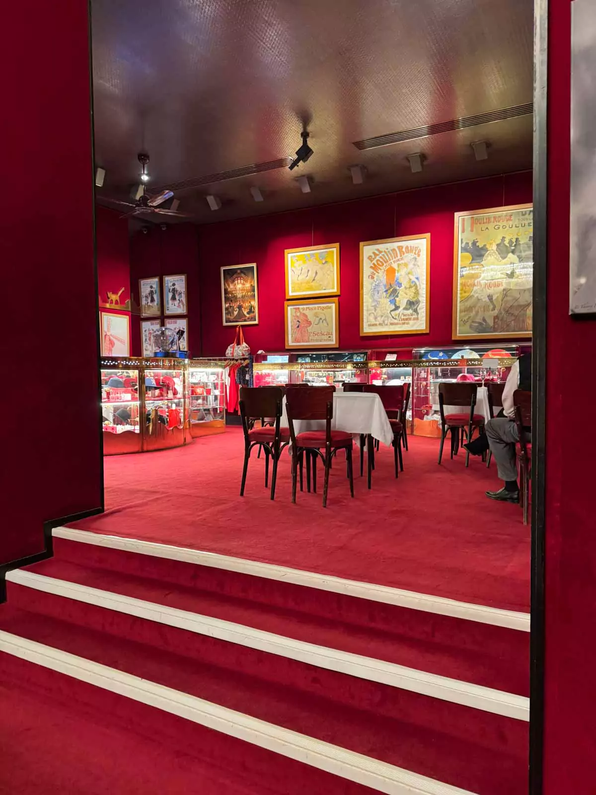Foyer bar inside the Moulin Rouge in Montmartre, Paris, featuring a glowing red counter, mirrored walls, and elegant lighting, setting the mood for a glamorous night at the cabaret.