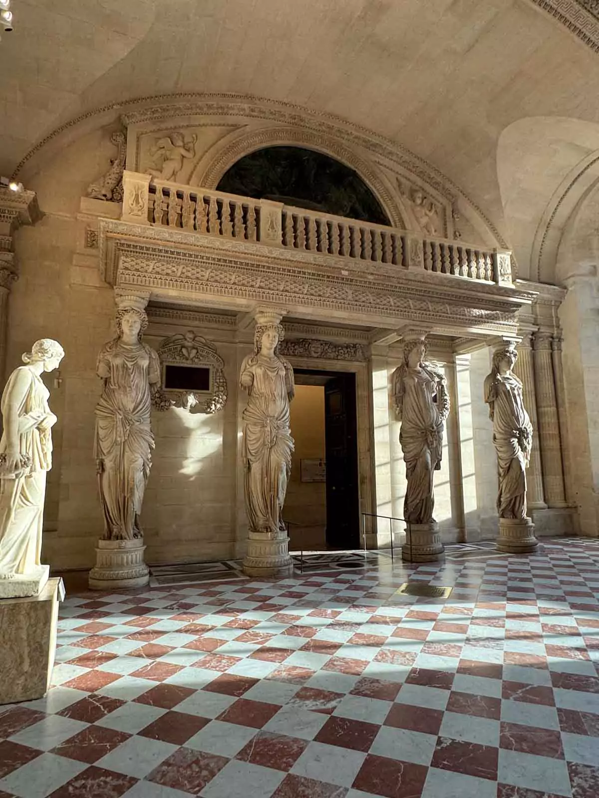 Caryatid sculpture by Jean Goujon at the Louvre Museum in Paris, France, featuring a gracefully carved female figure supporting an entablature, blending elegance and classical artistry — a timeless masterpiece