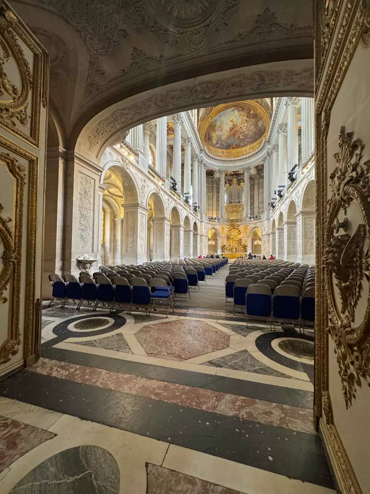 The Royal Chapel at the Palace of Versailles in Paris, France, featuring soaring vaulted ceilings, Corinthian columns, and a gilded organ above the altar