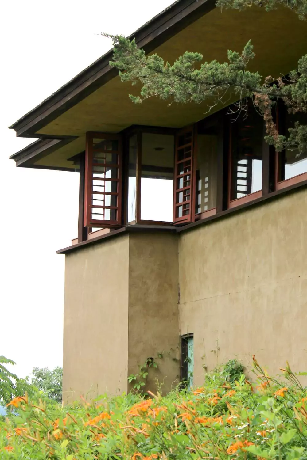 Frank Lloyd Wright’s Taliesin in Wisconsin, featuring the architect’s signature Prairie-style design with low, horizontal lines, natural stone, and integration into the surrounding landscape. The preserved estate reflects Wright’s vision of harmony between architecture and nature.