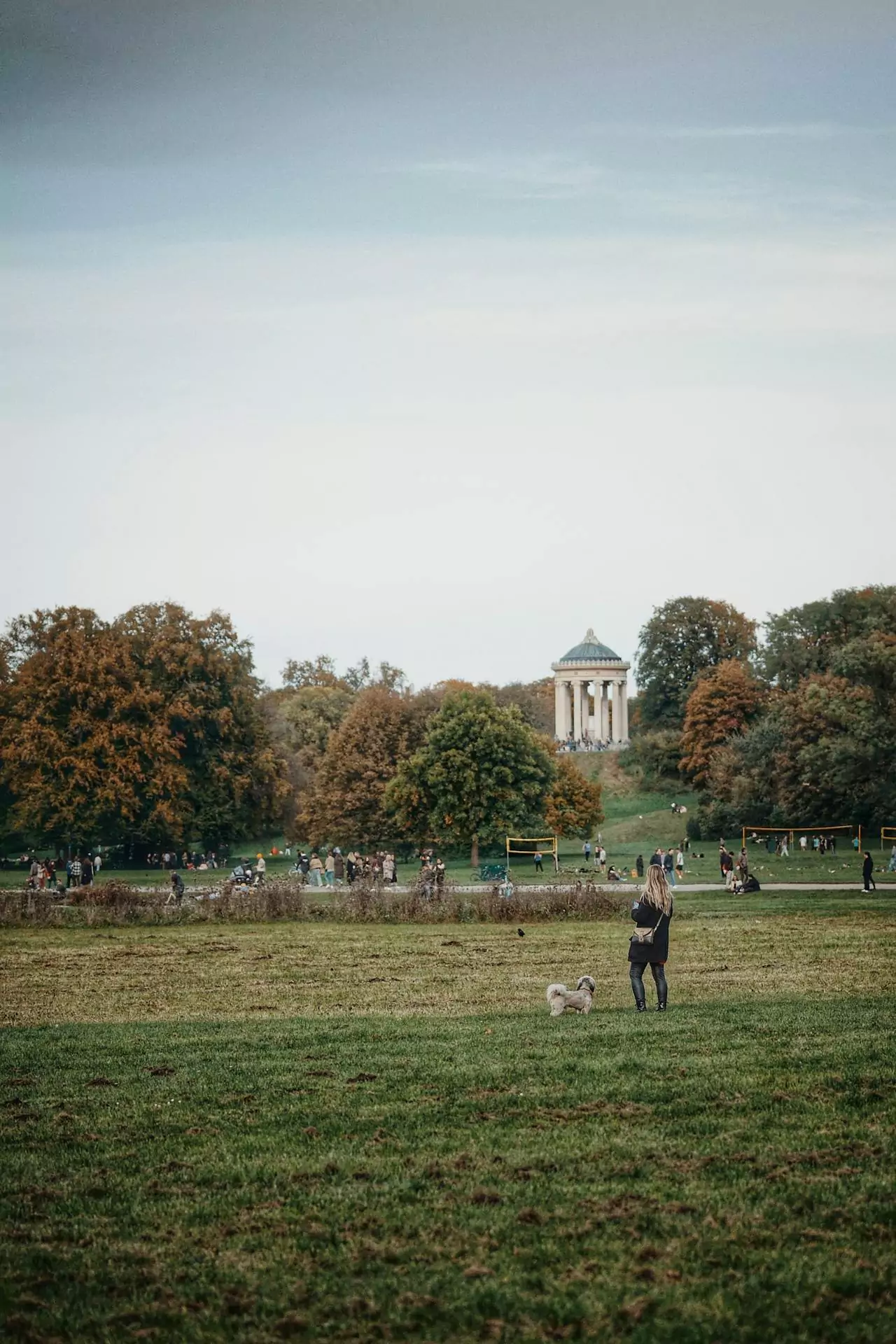 People enjoying a sunny day in Munich’s English Garden, relaxing on the grass, biking along tree-lined paths, and gathering near the streams and beer gardens in one of Europe’s largest urban parks.