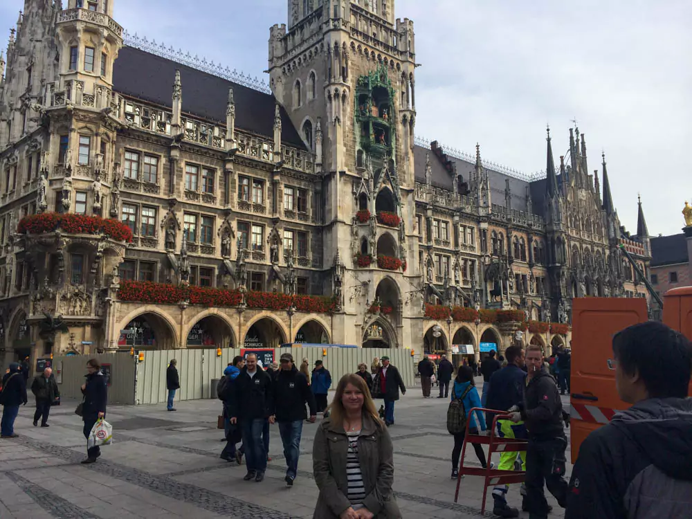 Katie standing in front of Marienplatz in Munich, Germany, smiling with the New Town Hall and its famous Glockenspiel behind her, capturing the charm of the historic city square.