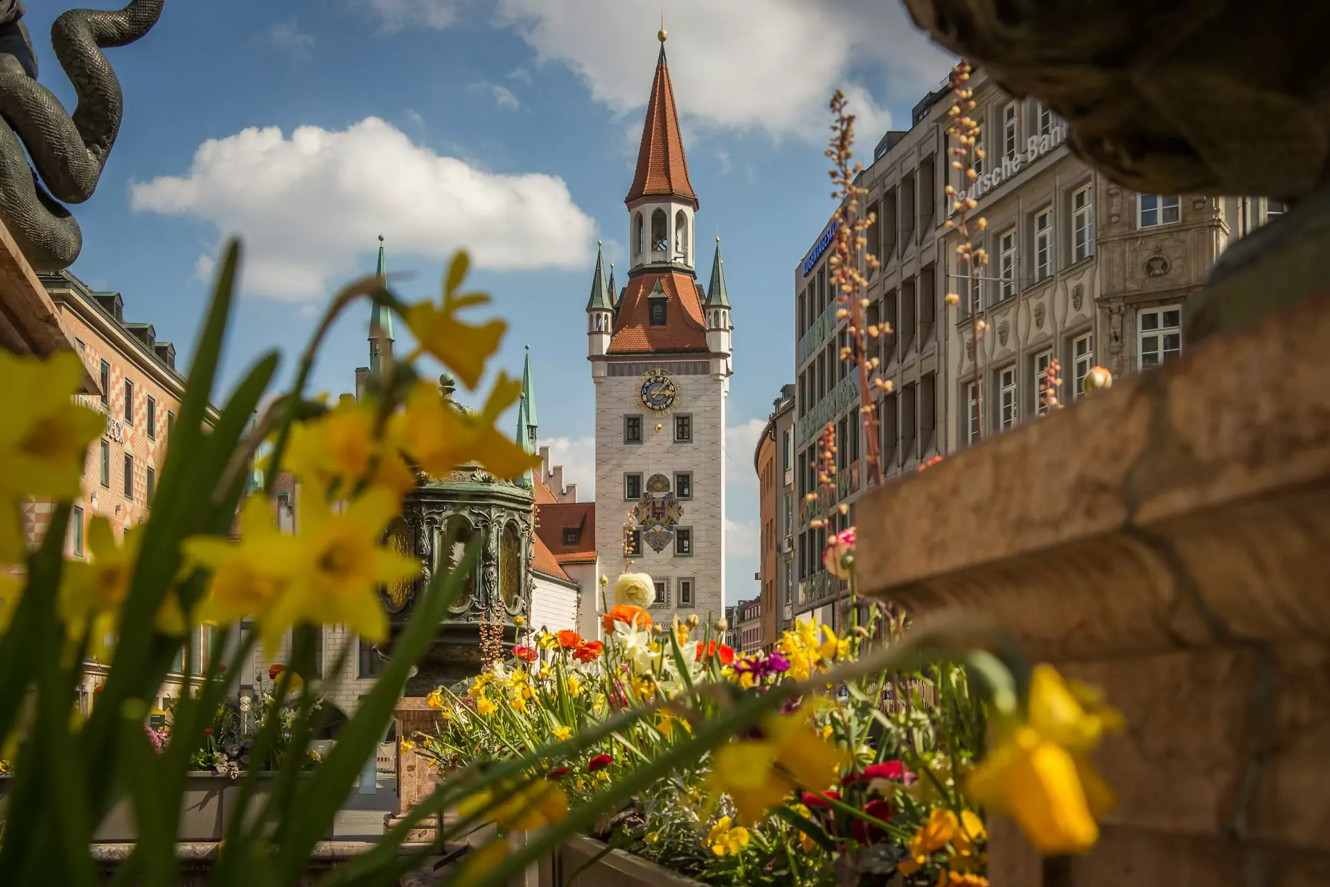 Munich’s Altes Rathaus (Old Town Hall), featuring its white façade, red-tiled spire, and Gothic architectural details, located at the eastern end of Marienplatz in the city’s historic center.