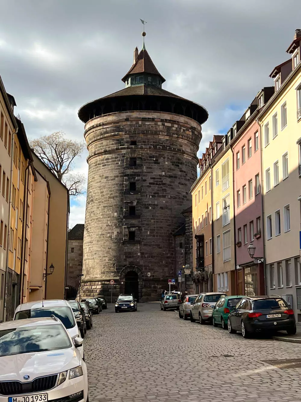 Rauentorturm in Nuremberg, Germany, a medieval round stone tower built into the city’s old defensive wall, standing beside the Handwerkerhof craft market near Königstor, with its historic architecture and red-tiled roof evoking the city’s medieval past.