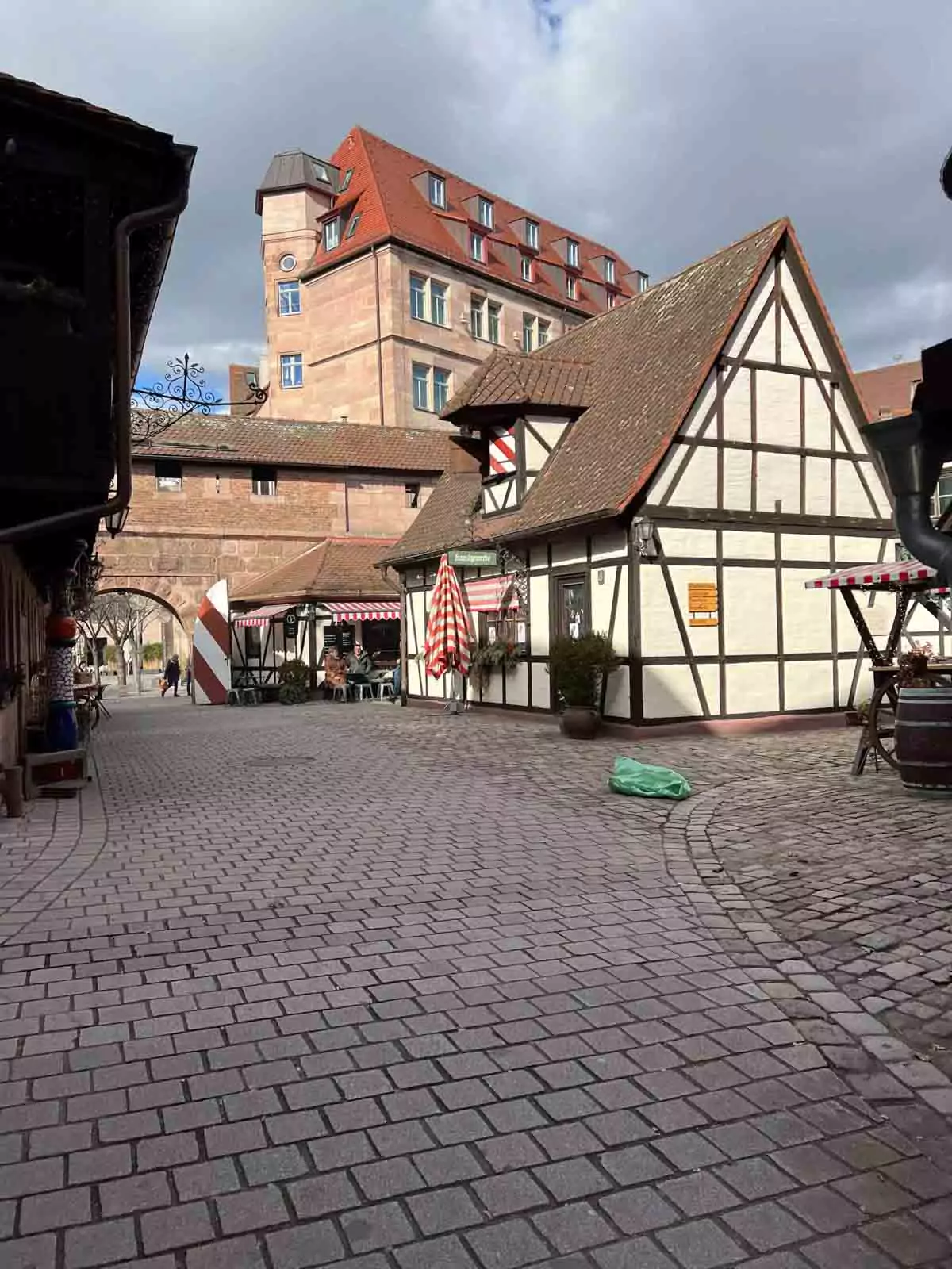 Handwerkerhof Nuremberg, a quaint medieval-style courtyard featuring half-timbered buildings, artisan shops, and cobblestone paths nestled beside the city’s old fortification walls.