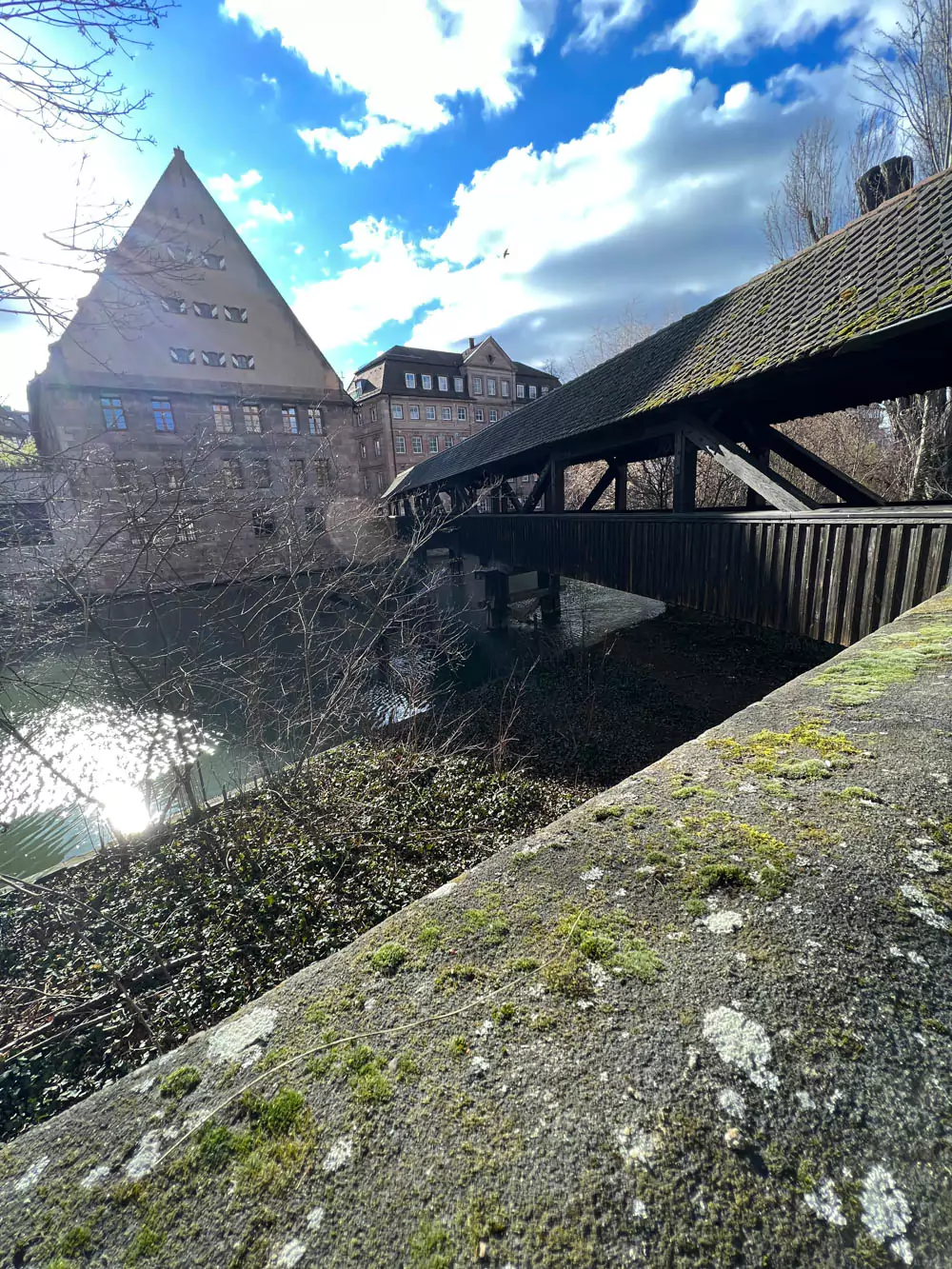 Henkersteg, or Hangman’s Bridge, in Nuremberg—a historic covered wooden footbridge crossing the Pegnitz River, leading to the medieval Weinstadel building.