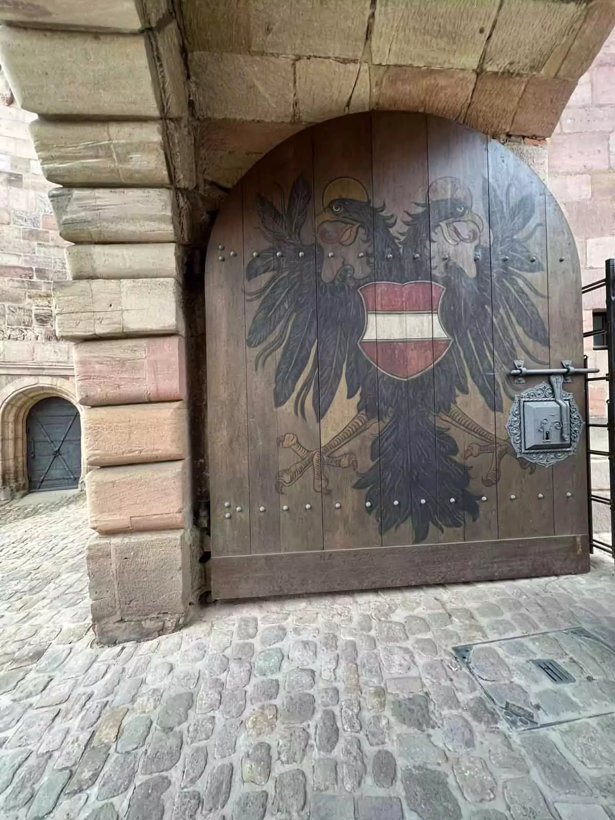 large arched wooden door with emblem painted on it
