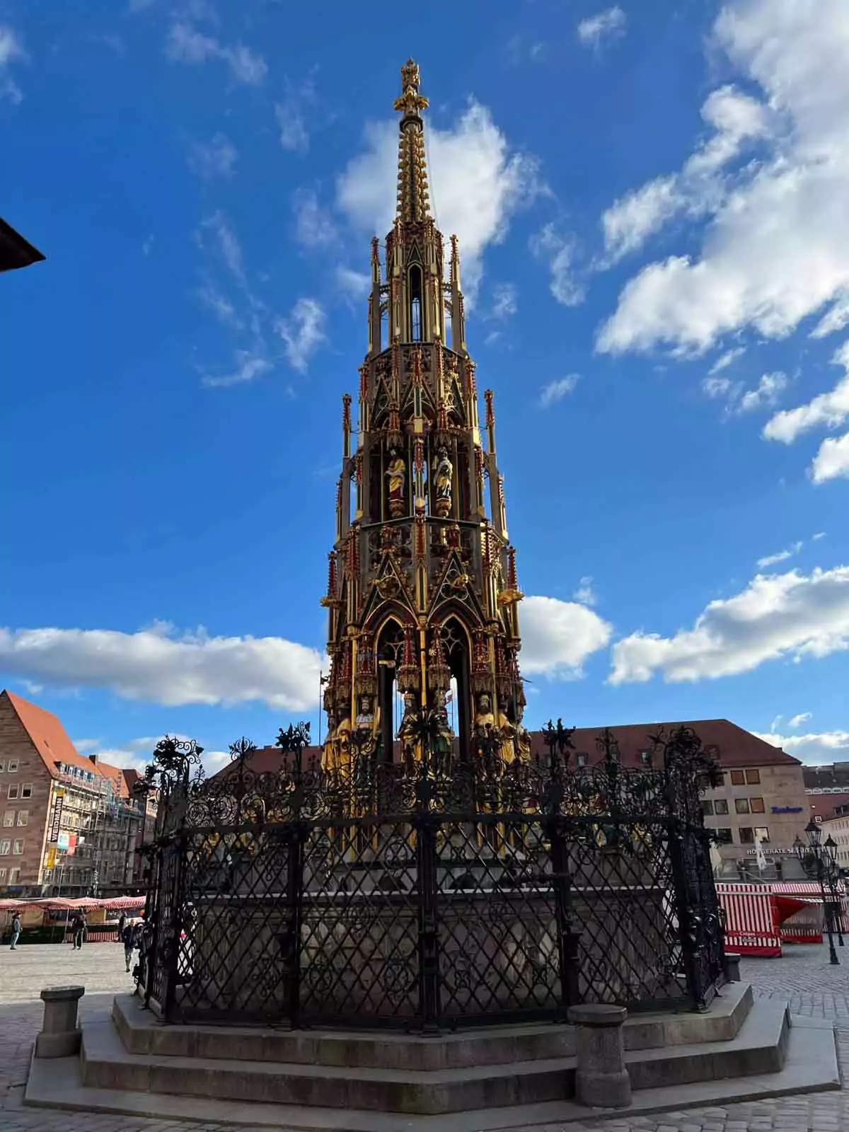 Schöner Brunnen, a 14th-century Gothic fountain in Nuremberg’s main square, featuring 40 colorful sculpted figures and an ornate spire-like design.
