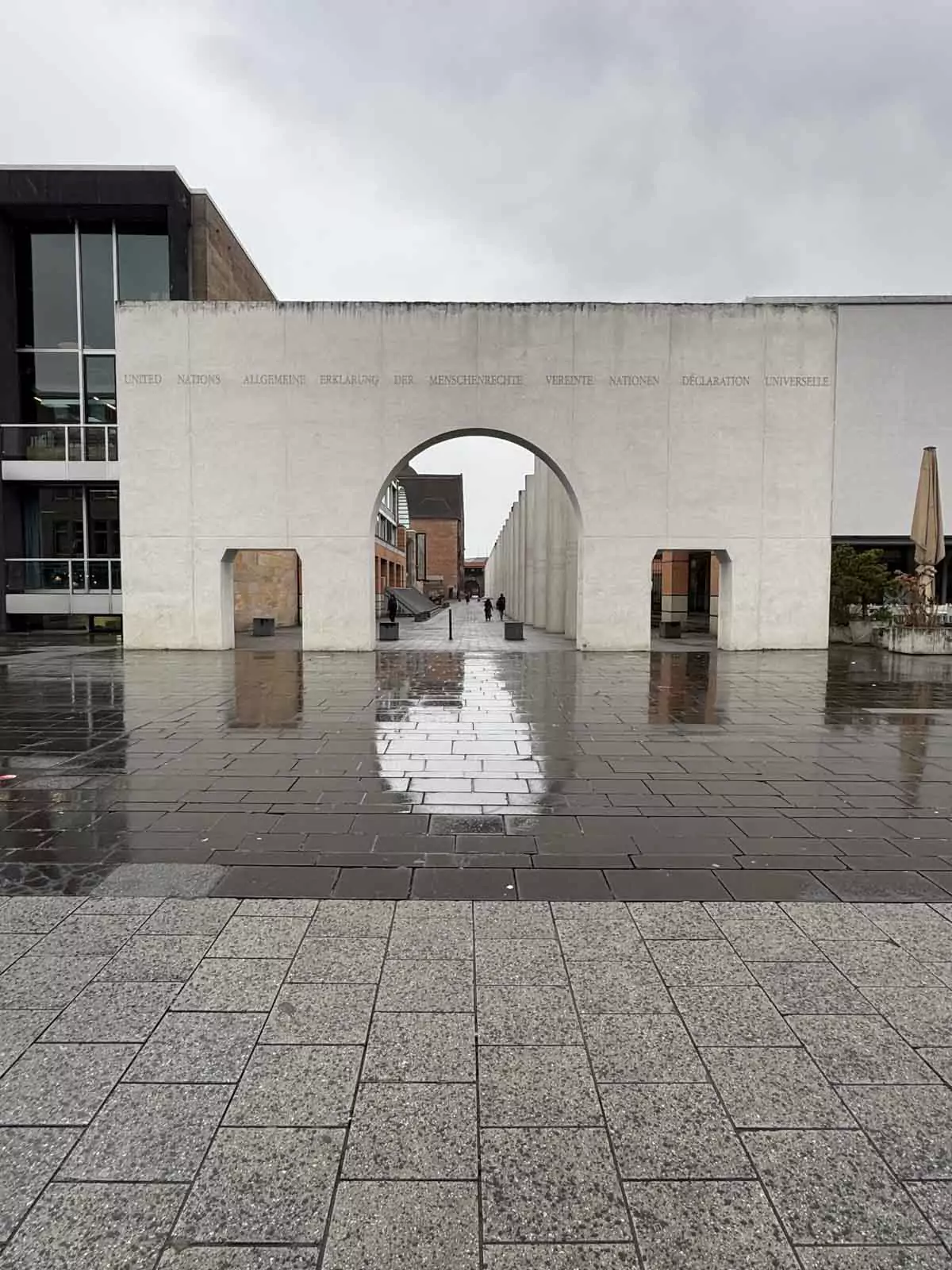 The Way of Human Rights in Nuremberg, Germany, featuring tall white pillars inscribed with articles from the Universal Declaration of Human Rights, lining a walkway beside the Germanisches Nationalmuseum.
