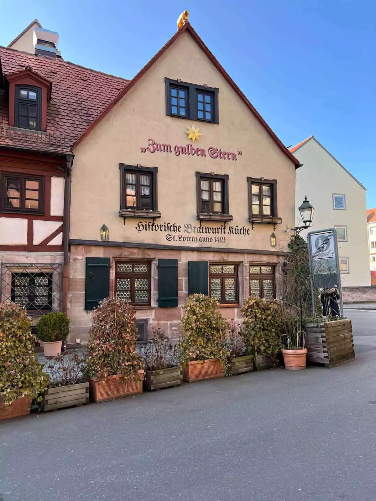 Exterior of Zum Gulden Stern in Nuremberg, Germany—one of the world’s oldest bratwurst restaurants—featuring a historic half-timbered facade, red shutters, and traditional signage in Nuremberg’s Old Town.