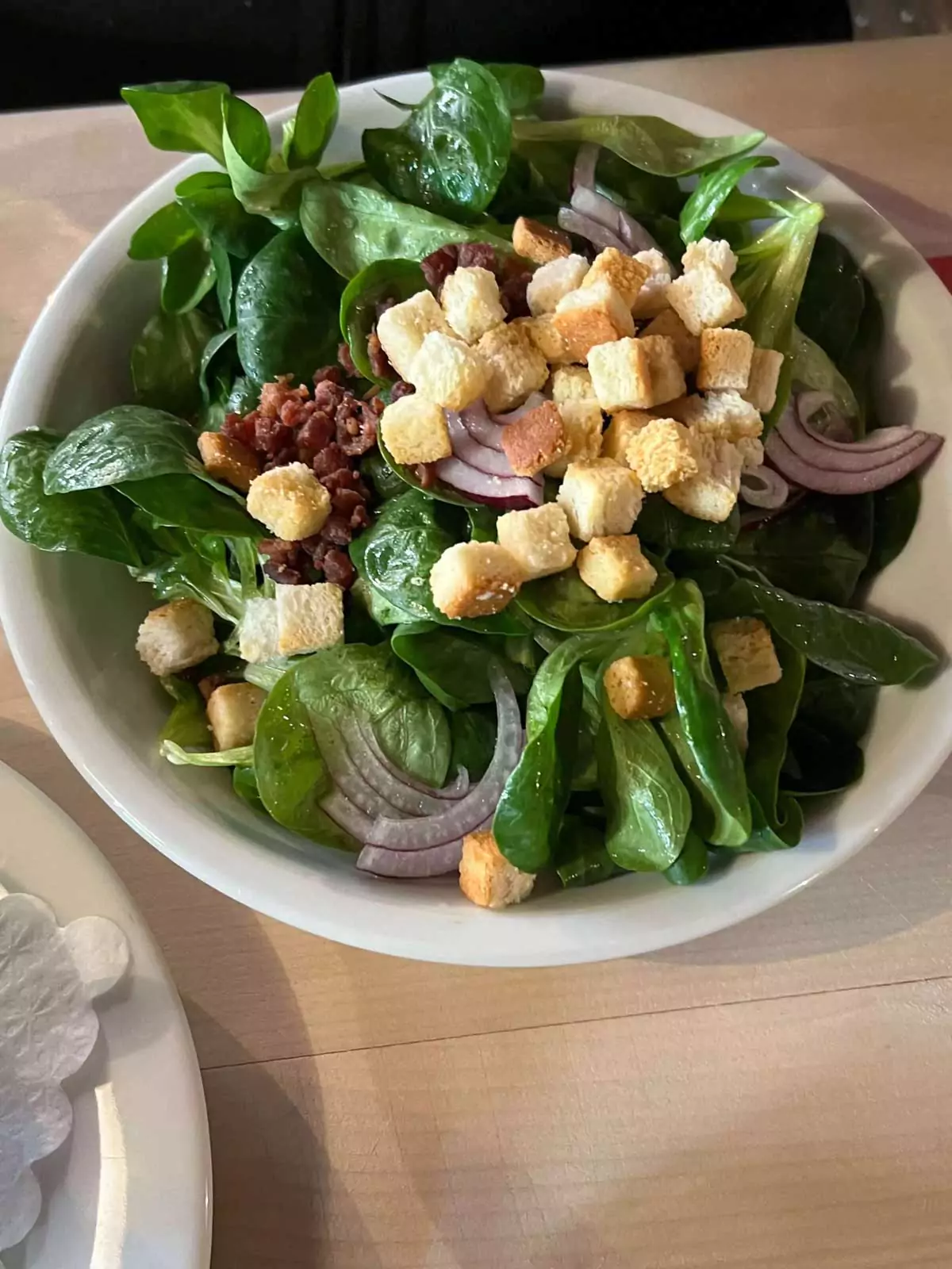 Fresh mixed salad served at Zum Gulden Stern in Nuremberg, Germany, featuring crisp lettuce, shredded carrots, cucumbers, and tangy vinaigrette, presented in a simple, rustic bowl.