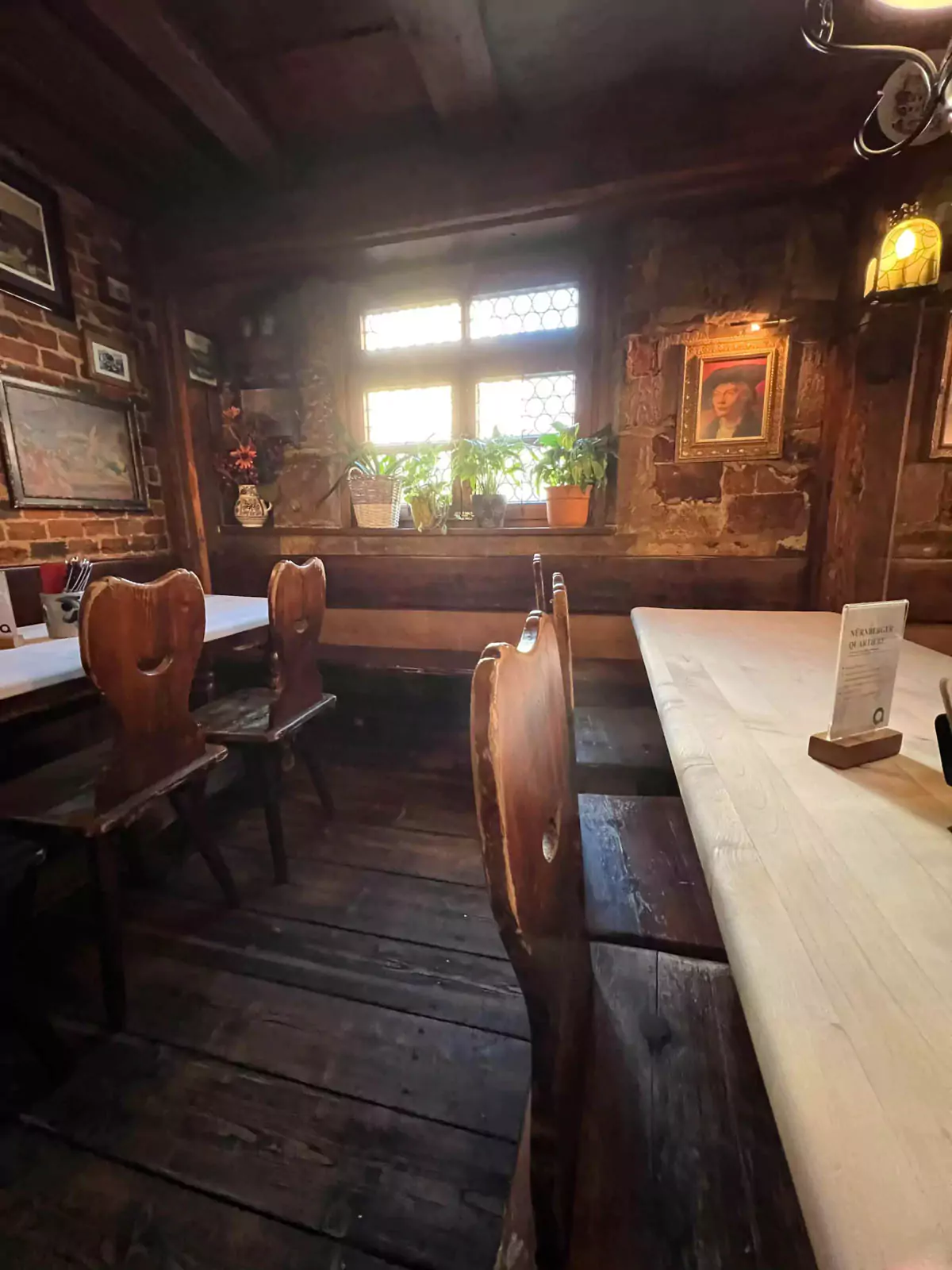Rustic interior of Zum Gulden Stern in Nuremberg, Germany, featuring wooden tables and chairs, exposed timber beams, and traditional decor that reflects the restaurant’s historic charm.