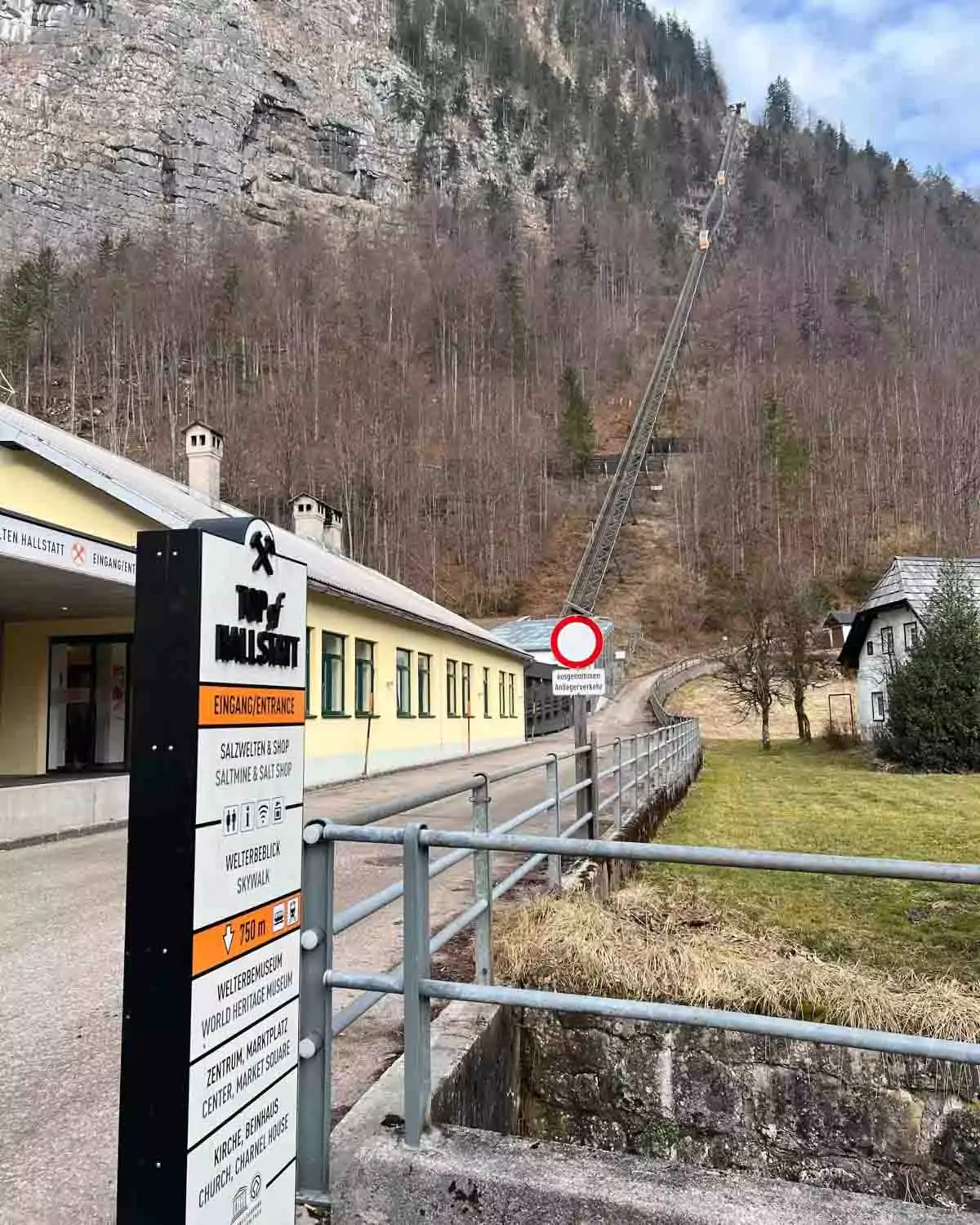 Small train heading up to the Hallstatt Salt Mine (Salzwelten) in Austria, winding through alpine forested slopes with views of the surrounding mountains and village below.