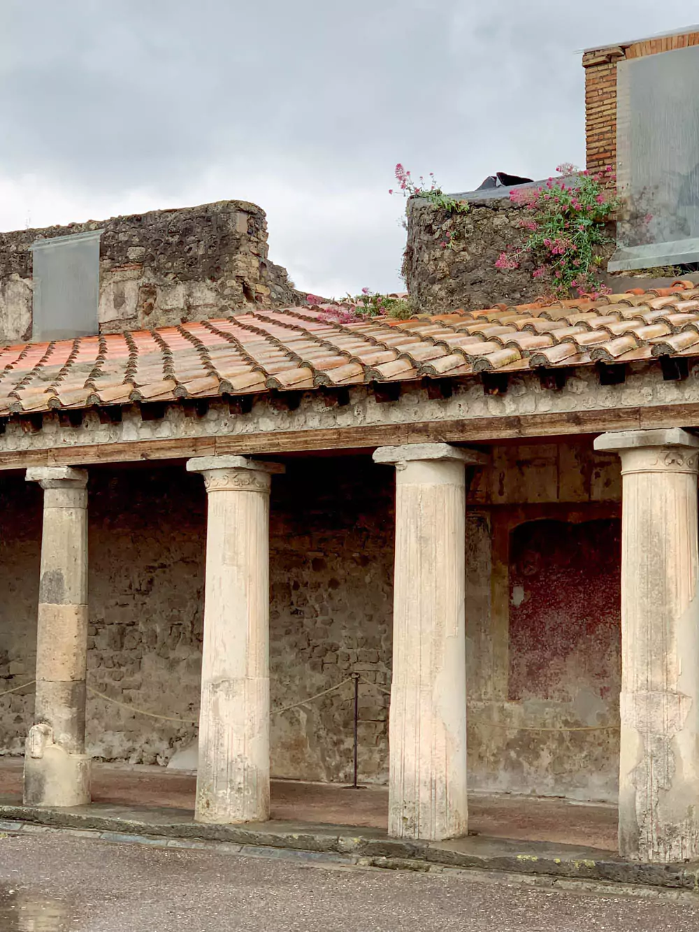 Columns of the Stabian Baths (Terme Stabiane) in the Archaeological Park of Pompeii, Italy, showcasing well-preserved Roman architecture with stone pillars surrounding the ancient thermal complex’s open courtyard.