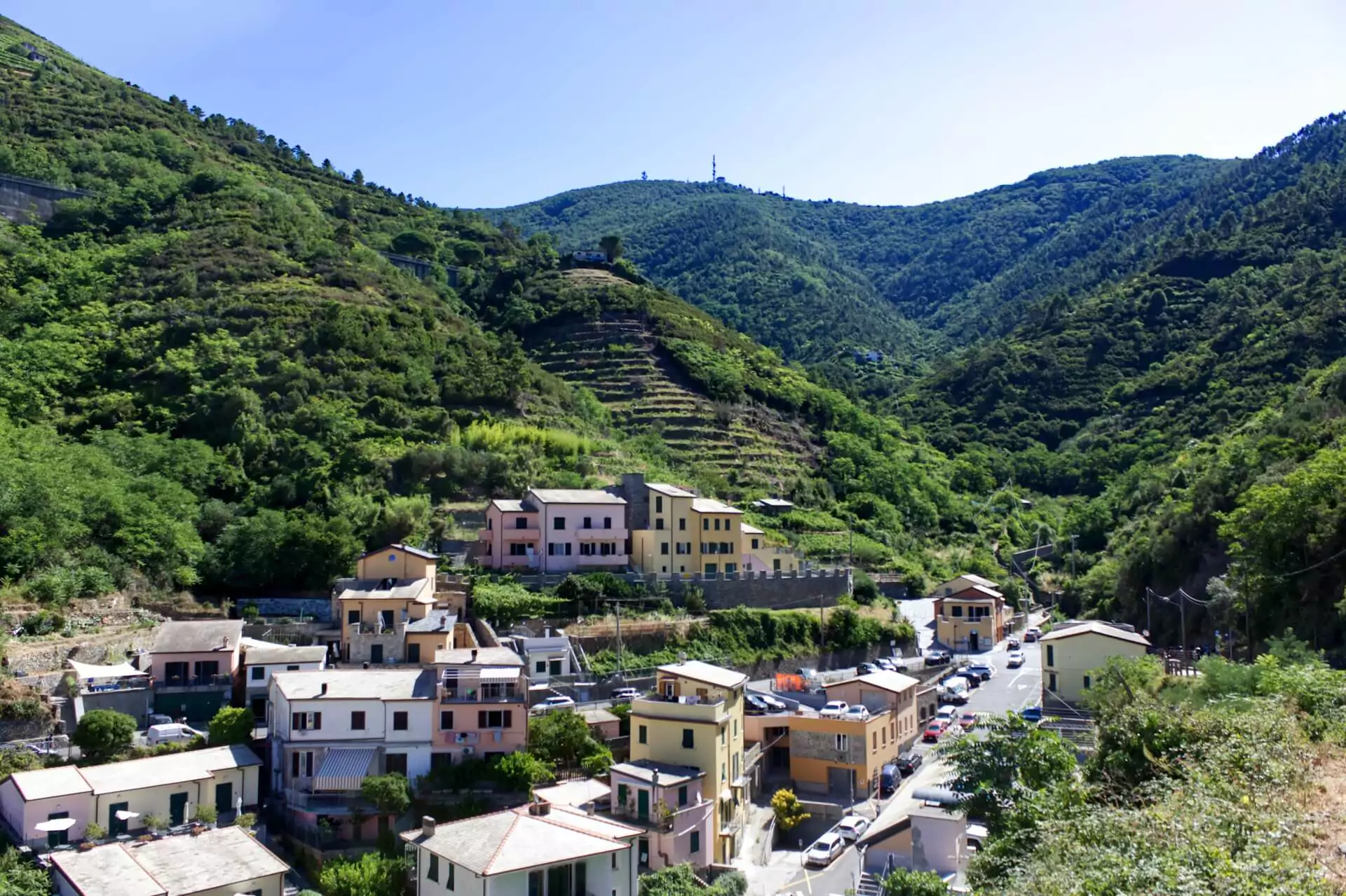 Colorful cliffside villages of Cinque Terre, Italy, with stacked pastel buildings overlooking the Mediterranean Sea, terraced vineyards on the hills.