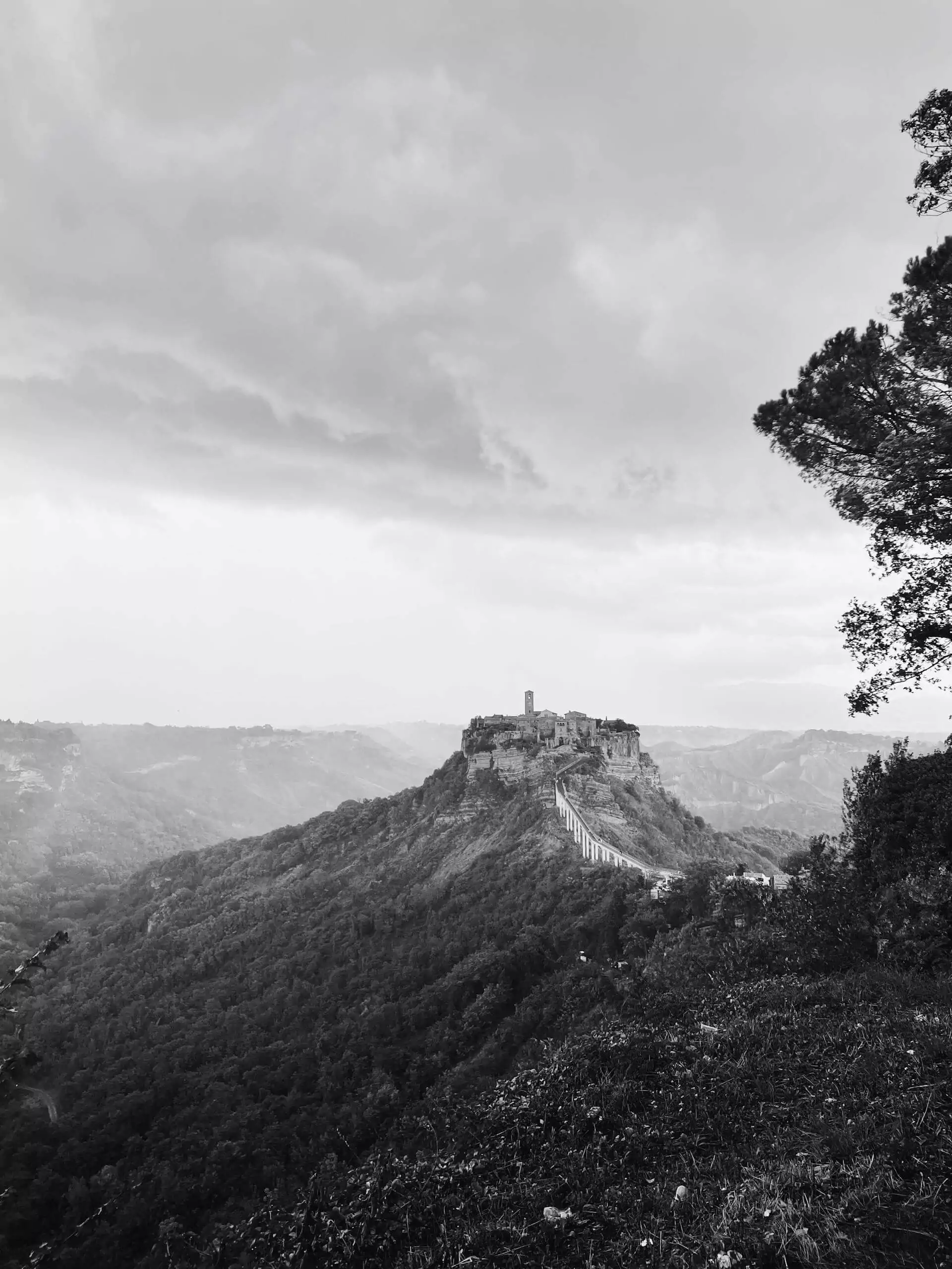 Civita di Bagnoregio, a hilltop town in the province of Viterbo, Italy, perched on a crumbling plateau of volcanic rock and connected by a narrow pedestrian bridge, known for its striking isolation and medieval architecture.