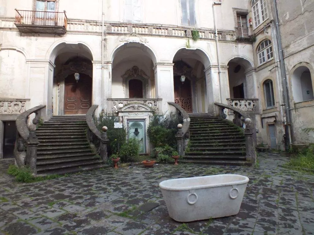 The doppia gradinata, or double staircase, at the Museo delle Arti Sanitarie in Naples, Italy, featuring elegant curved stone steps leading to the historic medical museum housed in a former hospital complex.
