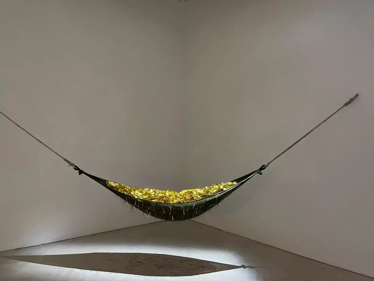 Contemporary art installation featuring a hammock inside the Museo Madre in Naples, Italy, set within a minimalist white gallery space, blending relaxation with modern artistic expression.