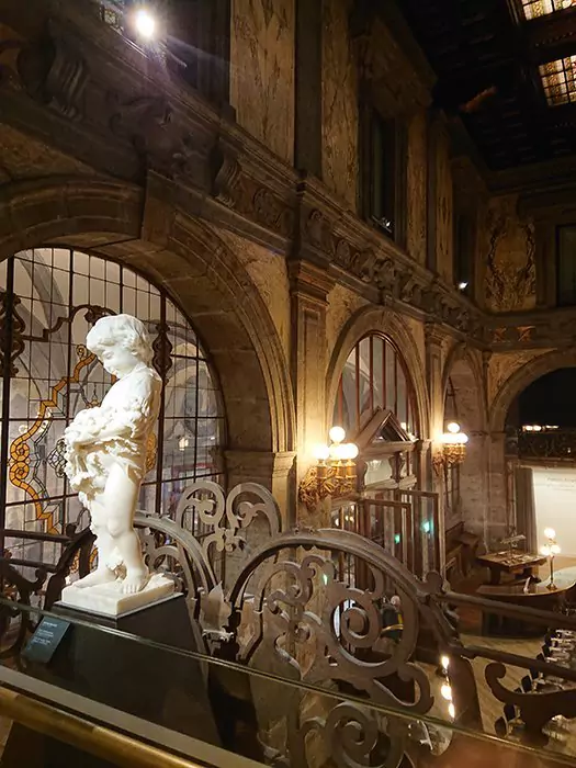 Interior of Palazzo Zevallos Stigliano in Naples, Italy, showcasing grand architectural details like marble floors, ornate balconies, and classical columns, now housing art exhibitions in a historic palatial setting.