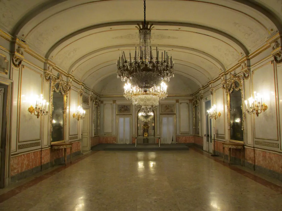 Exterior of Villa Pignatelli in Naples, Italy, a neoclassical mansion with white columns and symmetrical architecture, surrounded by manicured gardens and serving as a historic house museum.